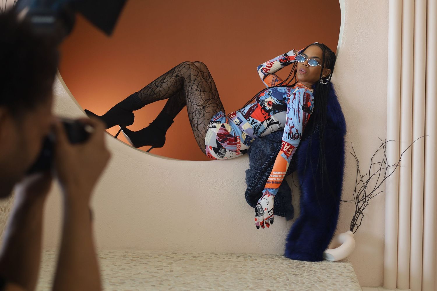 Creative fashion photoshoot featuring stylized poses against a neutral wall.