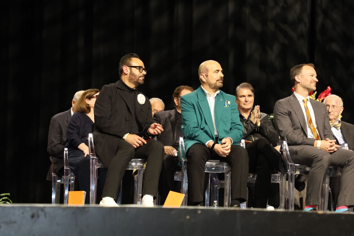 Faculty members in academic regalia seated at a graduation ceremony.