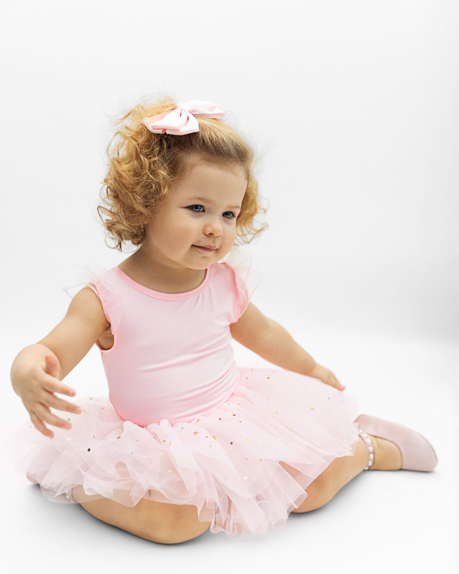 Baby wearing pink tutu dress poses gracefully on white background in multiple shots.