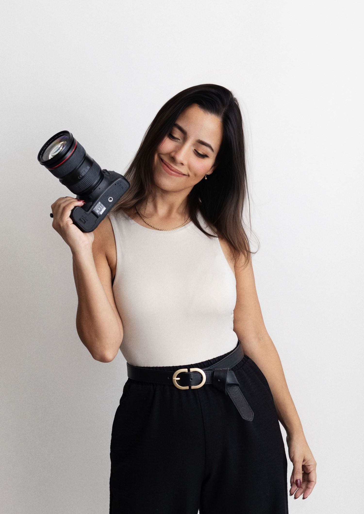 Newbell Photography. Venezuelan photographer in white aesthetic fine art style. poses with DSLR camera Canon r6. Houston TX