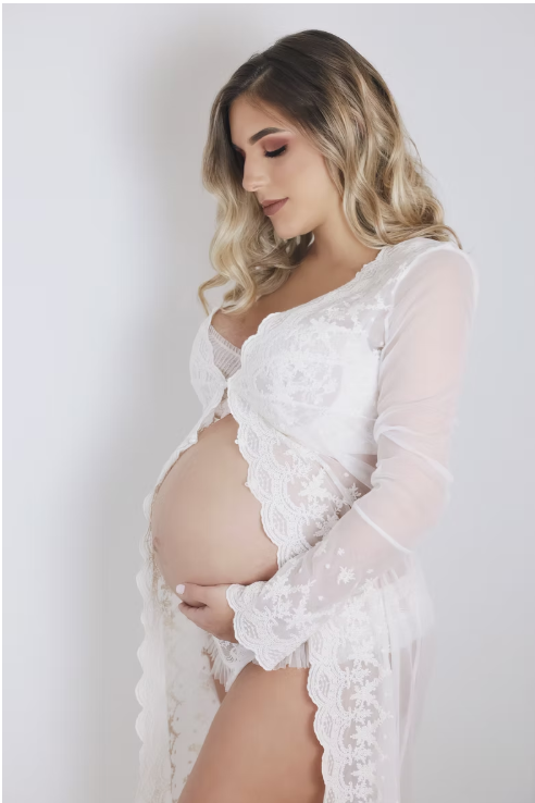 Artistic maternity photo series showing a pregnant woman in white lace against a light backdrop.