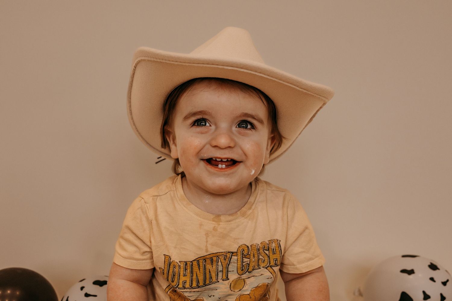 A series of six connected photos showing a baby in a beige hat and peach-colored shirt expressing different emotions.