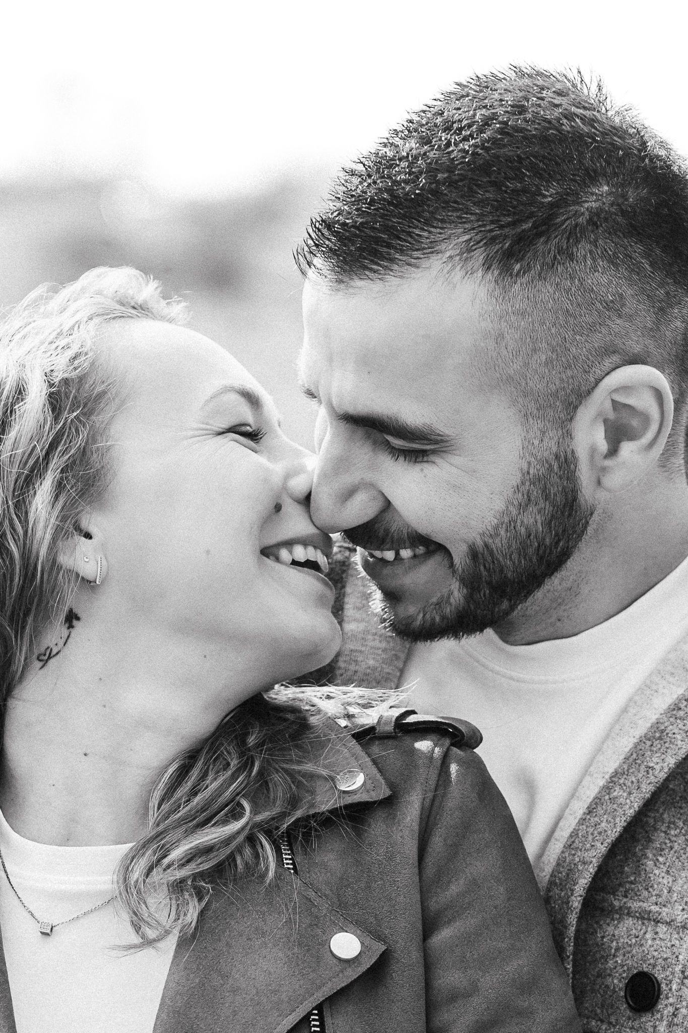 Relaxed couple portrait capturing genuine connection and laughter during a natural outdoor photoshoot