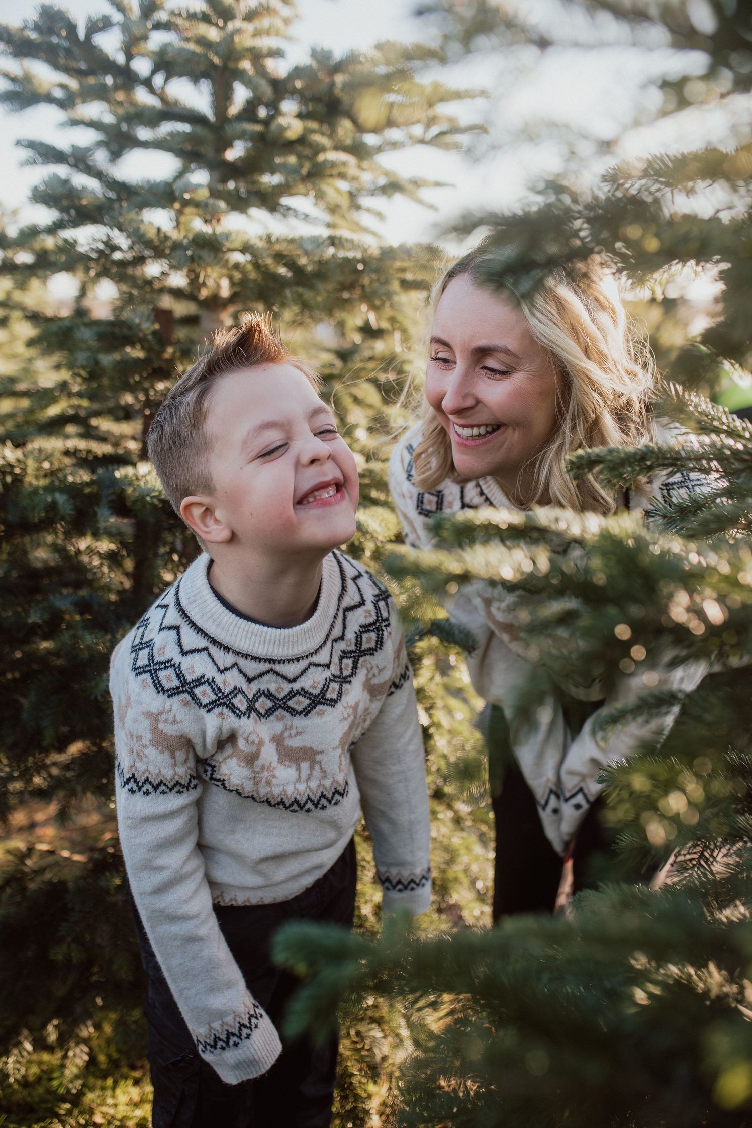 Natural family portrait of parents and children laughing together during an outdoor photography session in Kent.