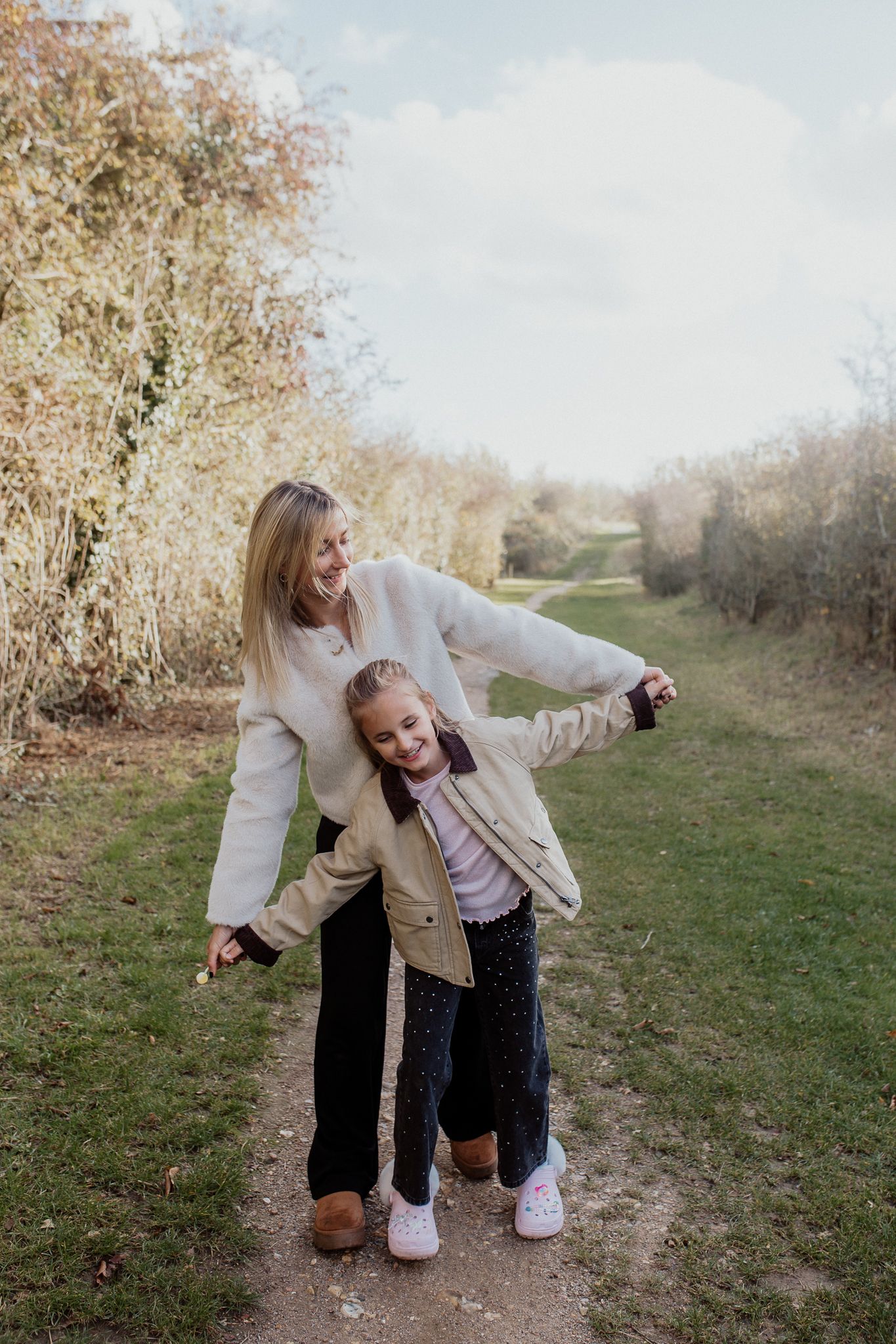 Natural family portrait of parents and children laughing together during an outdoor photography session in Kent.