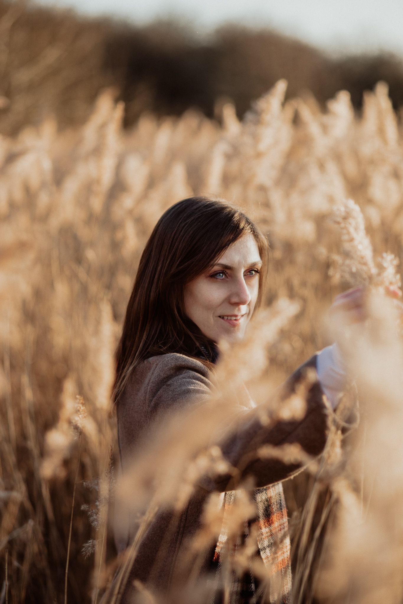 Natural lifestyle portrait of a woman in soft outdoor light, capturing authentic personality and emotion.