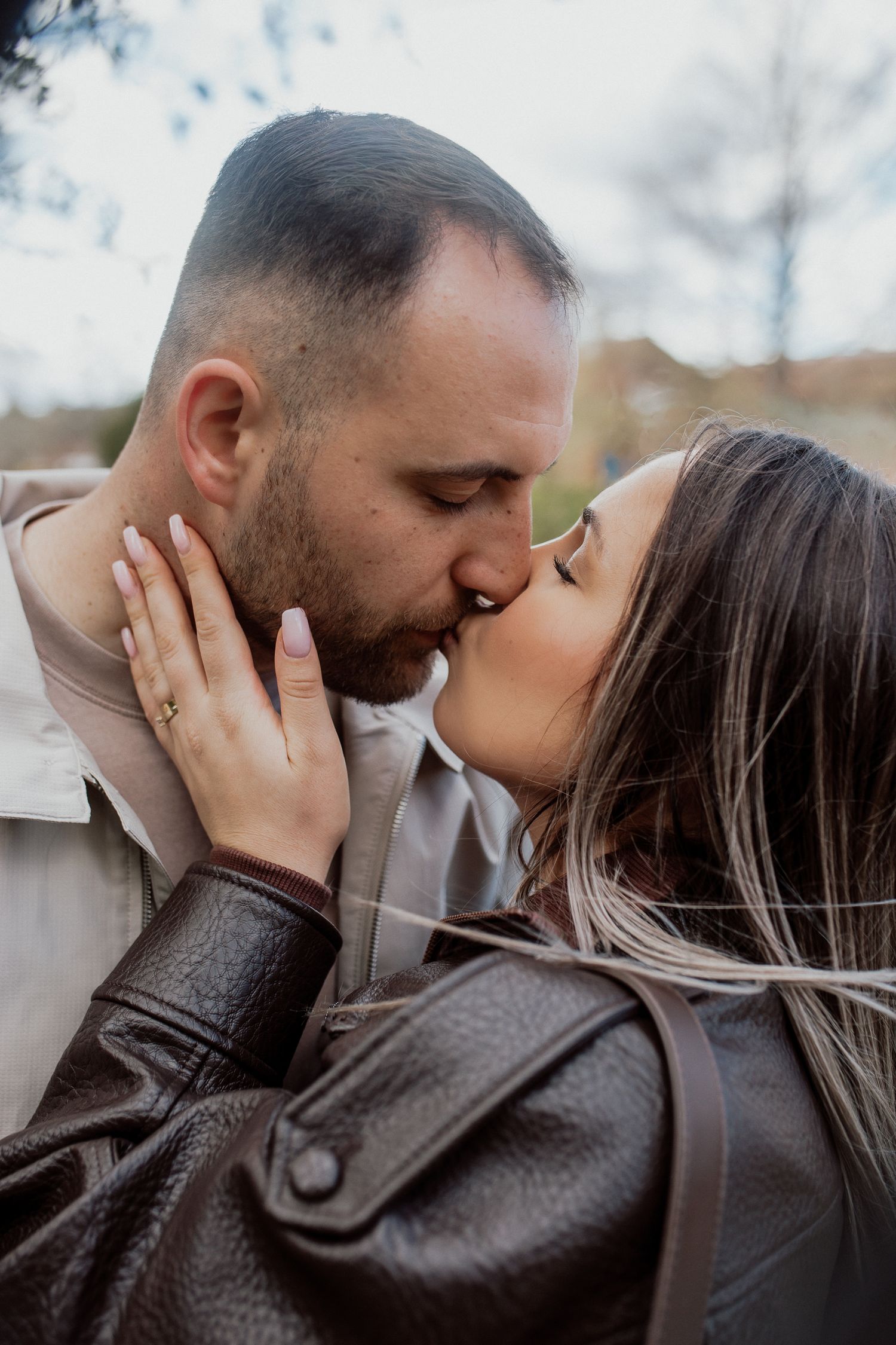 Relaxed couple portrait capturing genuine connection and laughter during a natural outdoor photoshoot