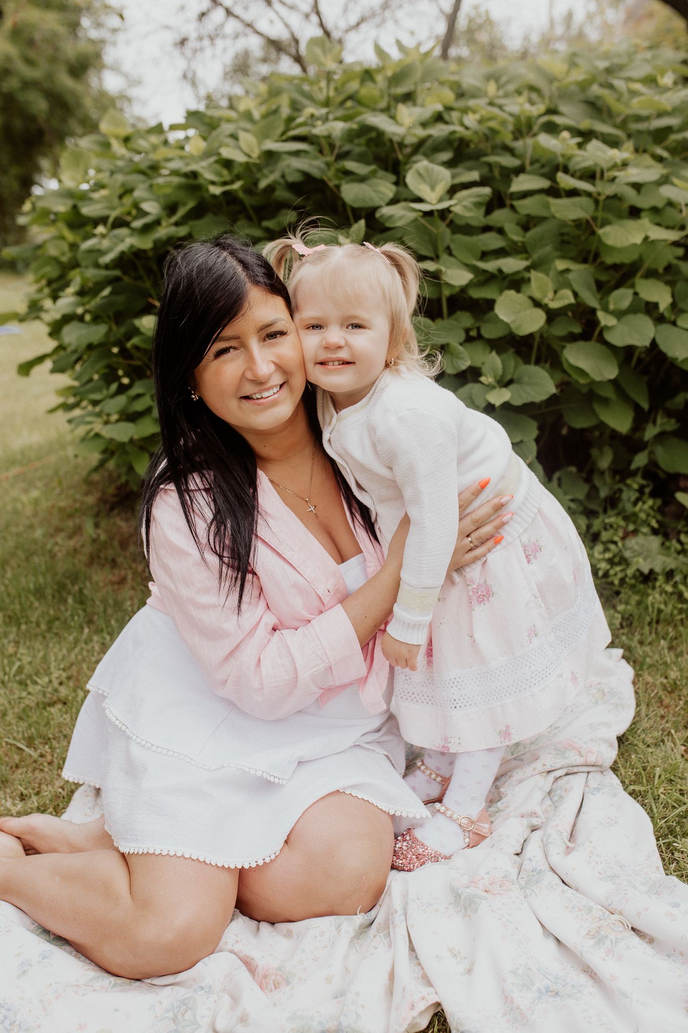 Natural family portrait of mother and daughter laughing together during an outdoor photography session in Latvia