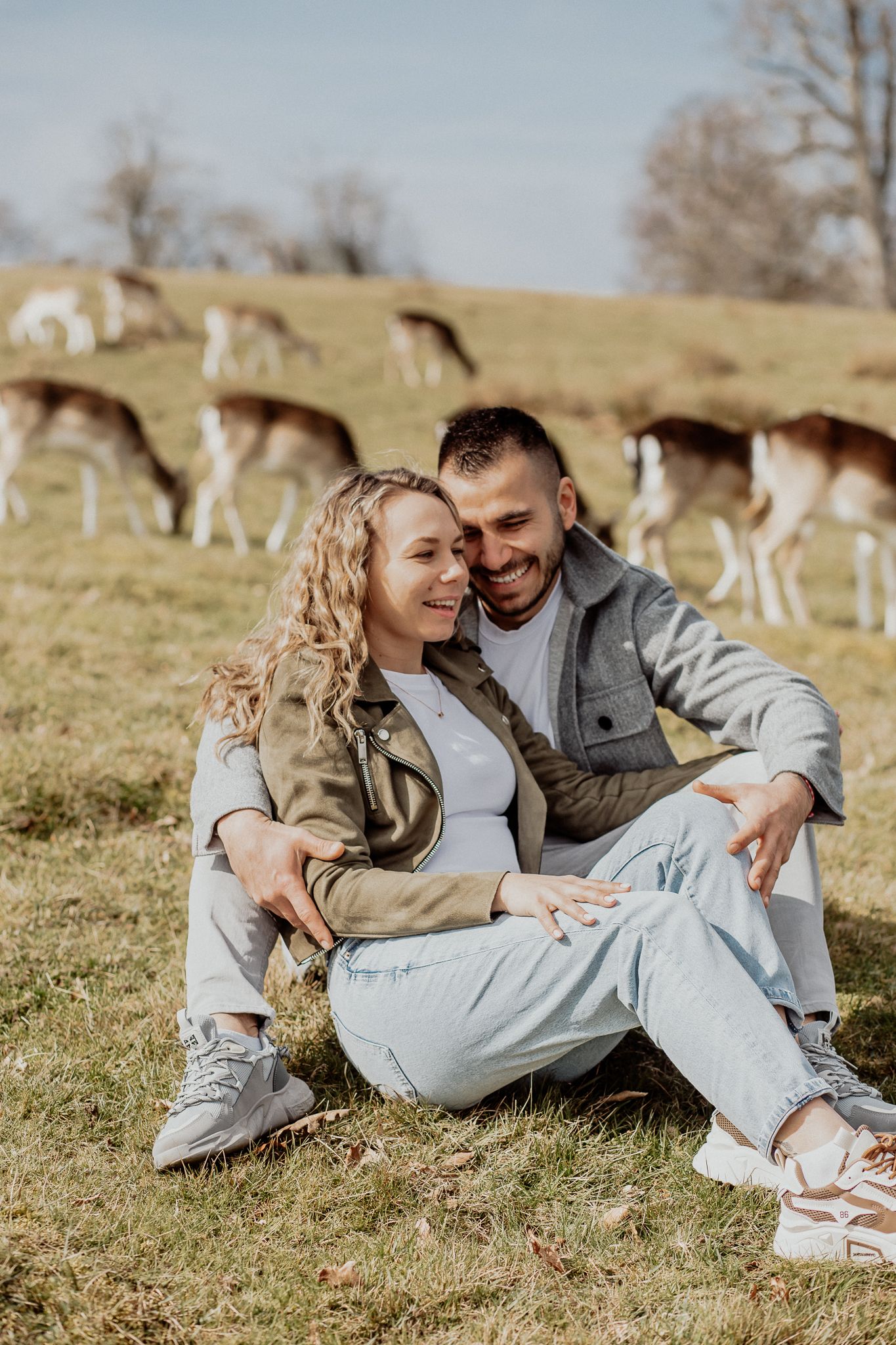 Relaxed couple portrait capturing genuine connection and laughter during a natural outdoor photoshoot