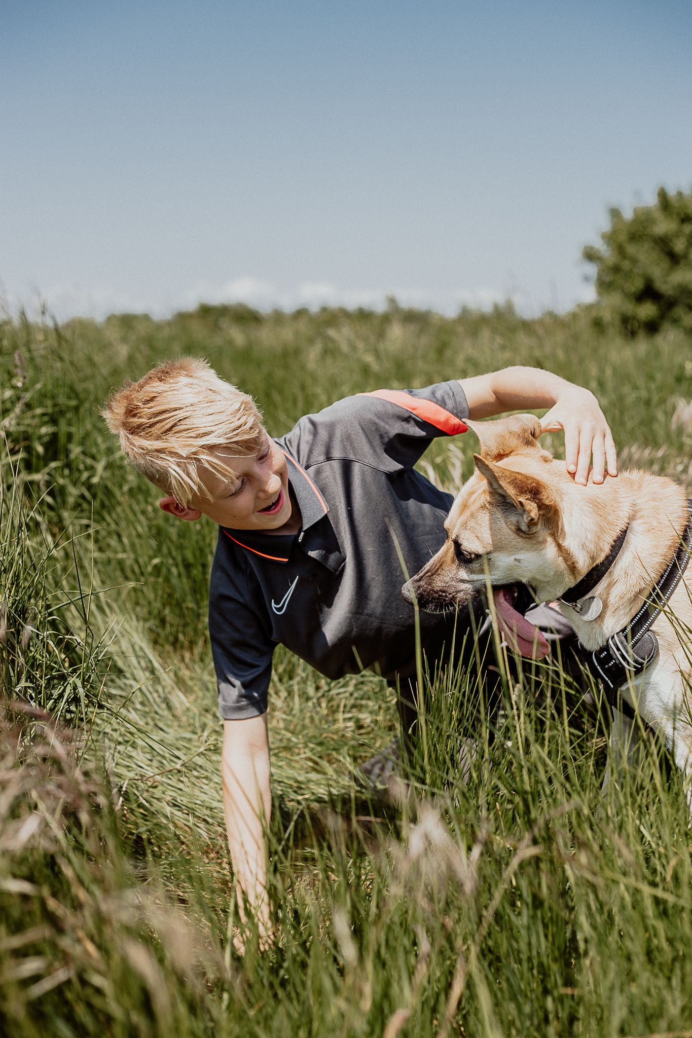 kid and dog playing in grass