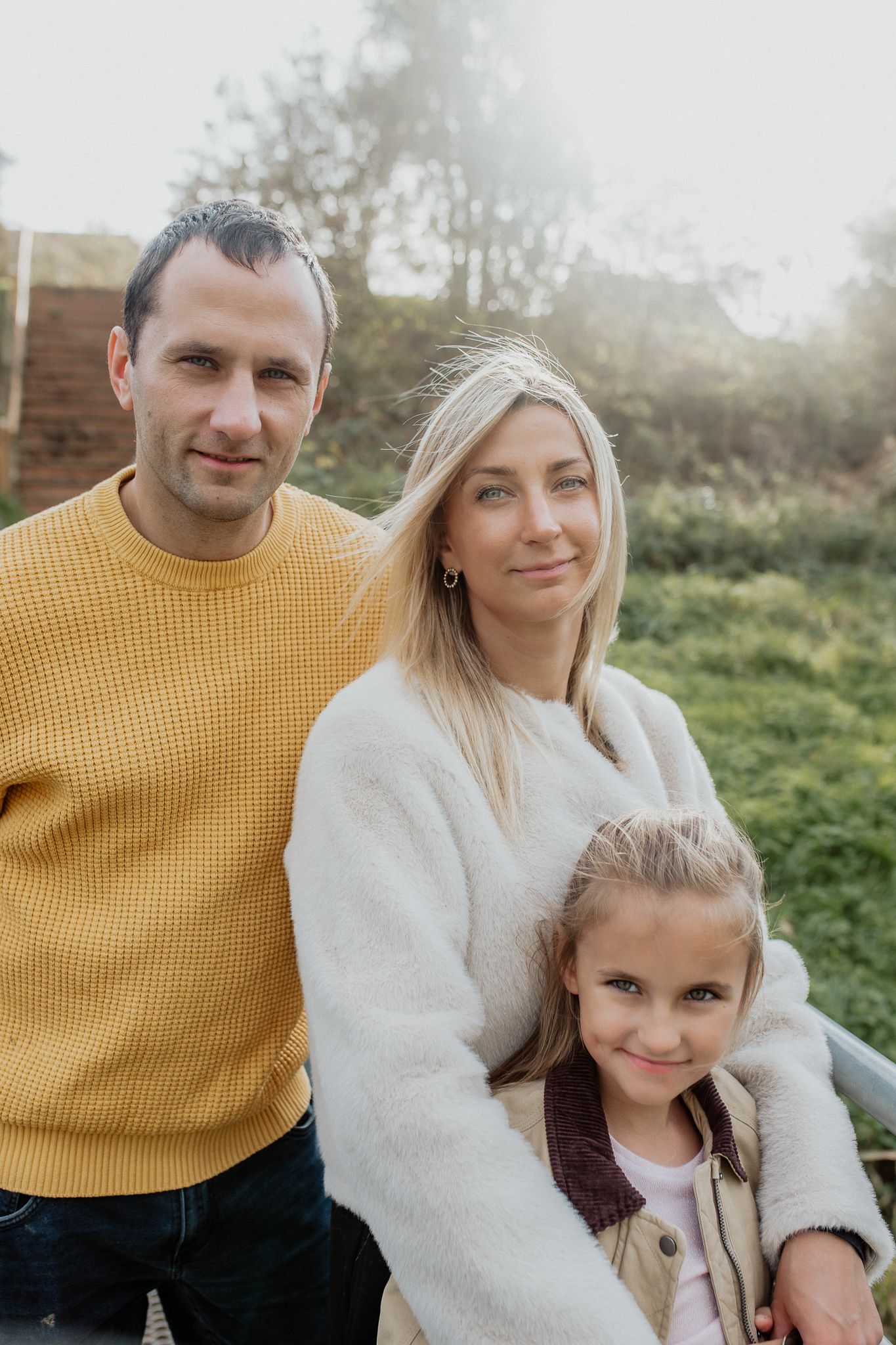 Natural family portrait of parents and children laughing together during an outdoor photography session in Kent.