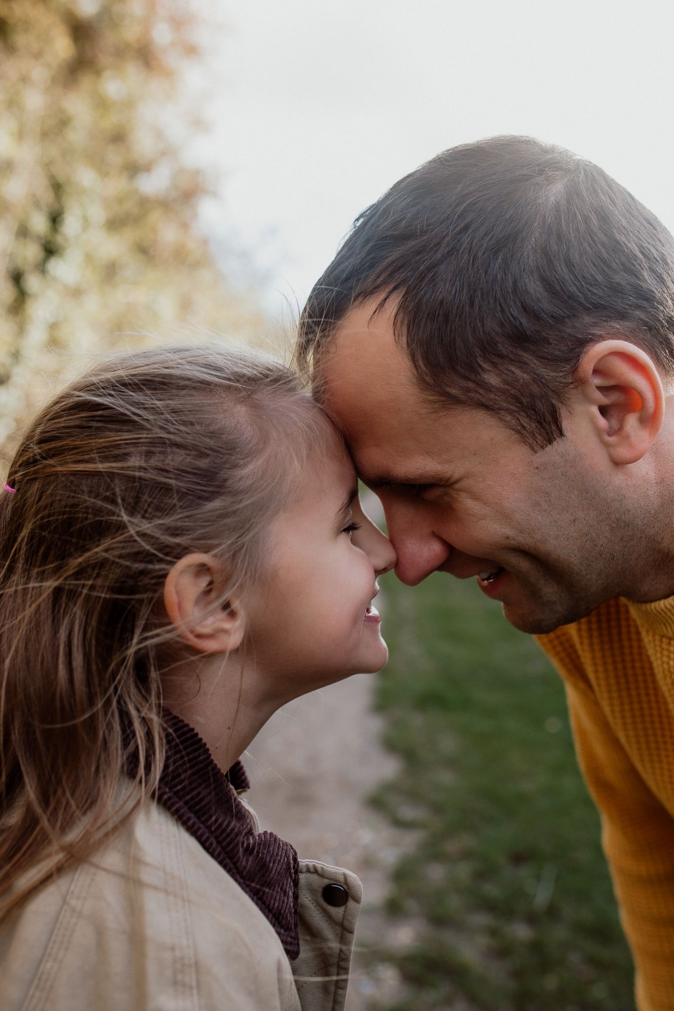 Natural family portrait of parents and children laughing together during an outdoor photography session in Kent.