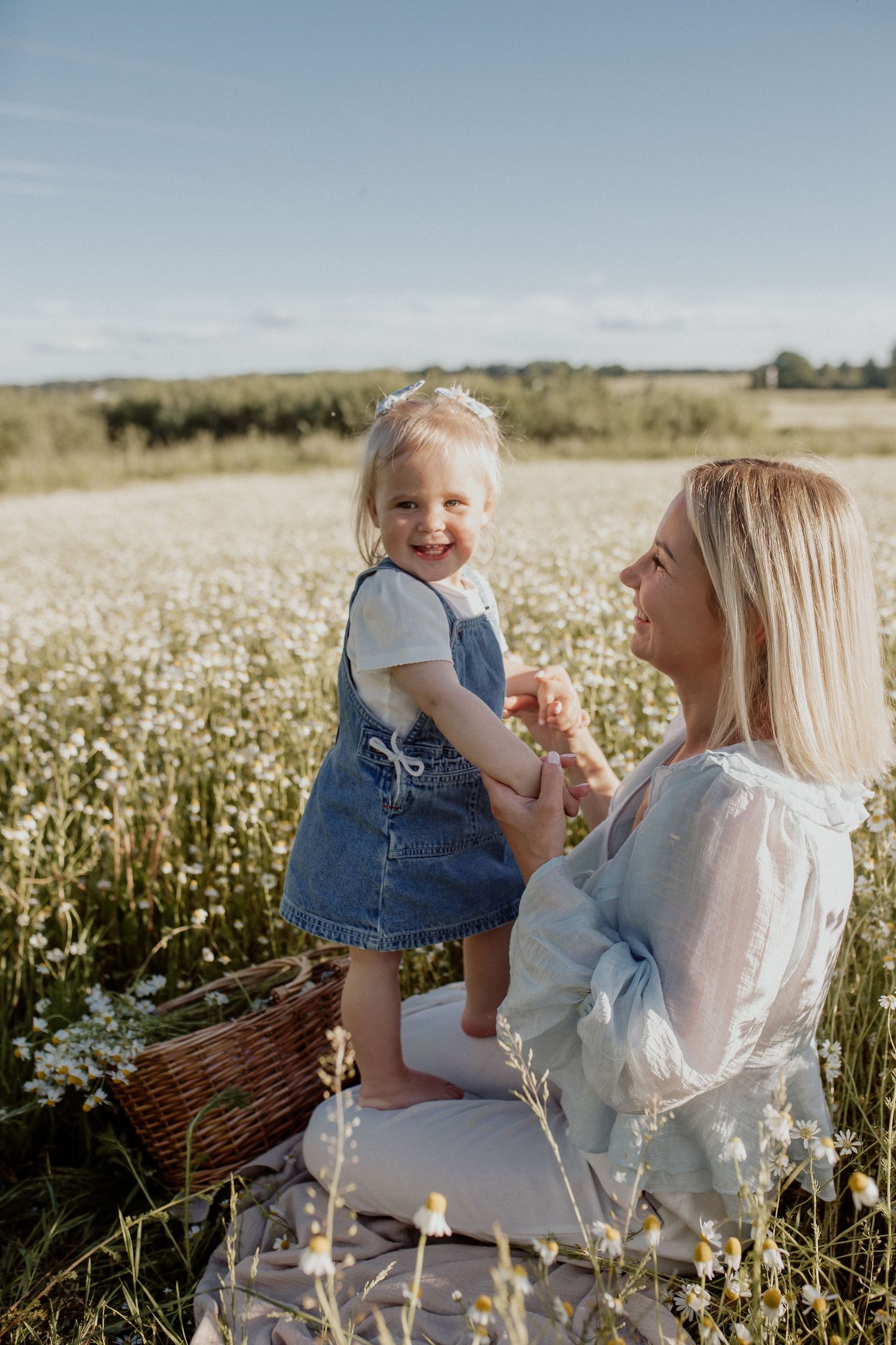 Natural family portrait of parents and children laughing together during an outdoor photography session in Latvia