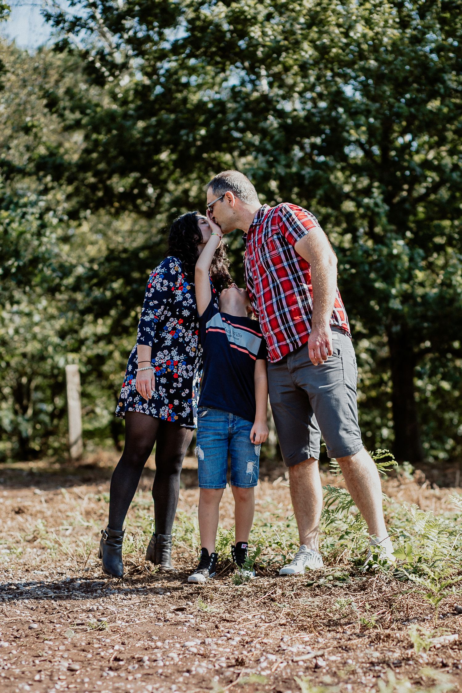 Natural family portrait of parents and children laughing together during an outdoor photography session in Kent.