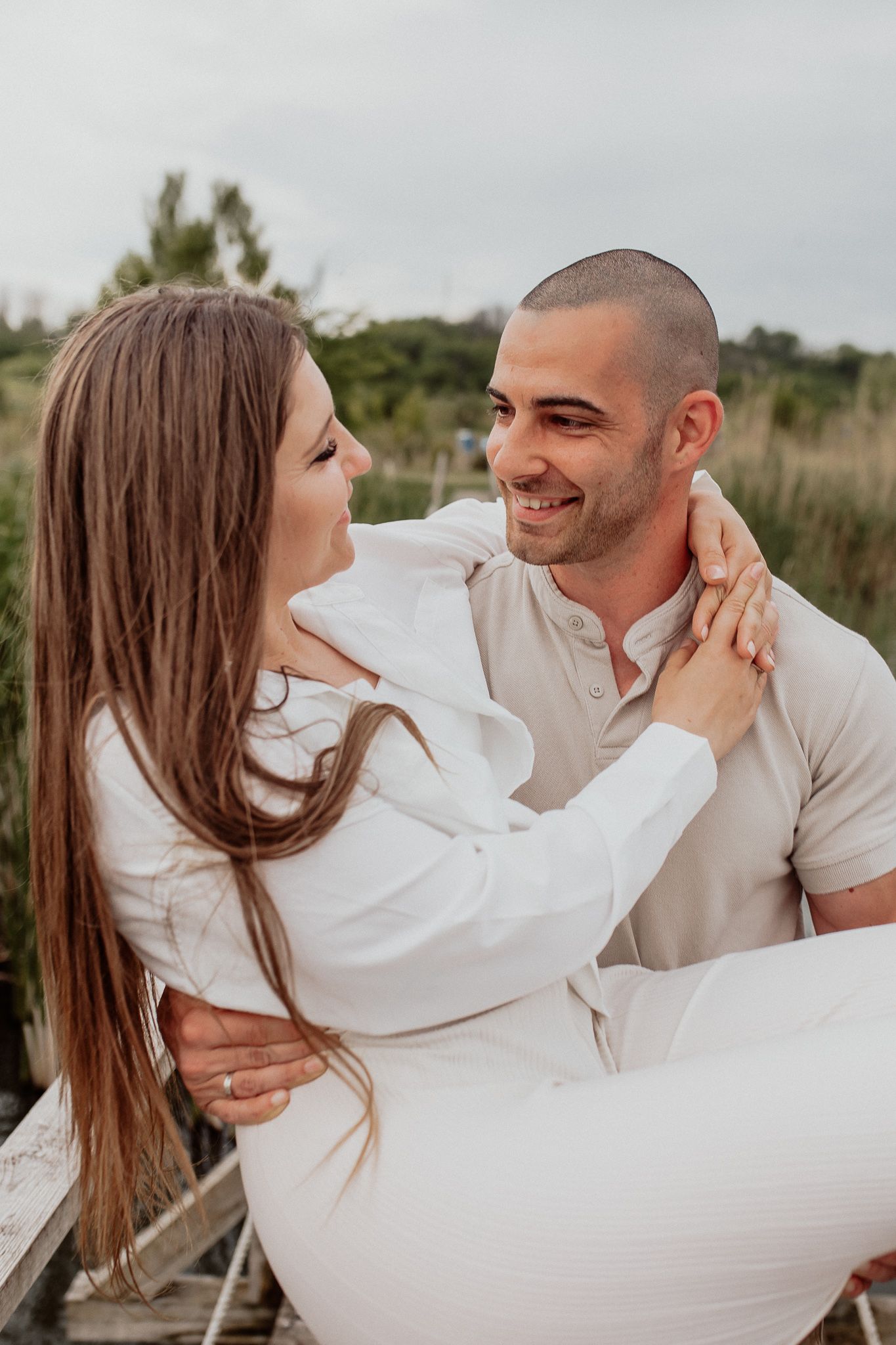 Relaxed couple portrait capturing genuine connection and laughter during a natural outdoor photoshoot