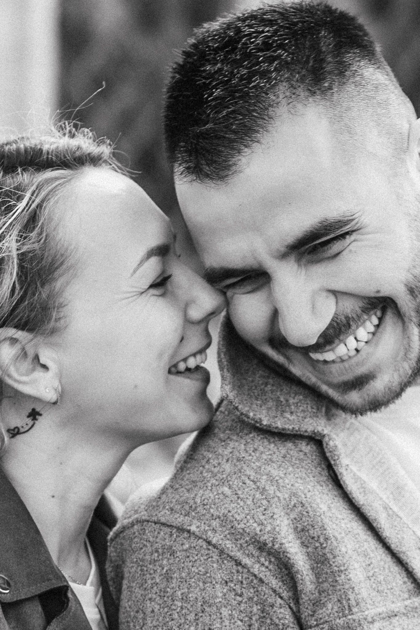 Relaxed couple portrait capturing genuine connection and laughter during a natural outdoor photoshoot