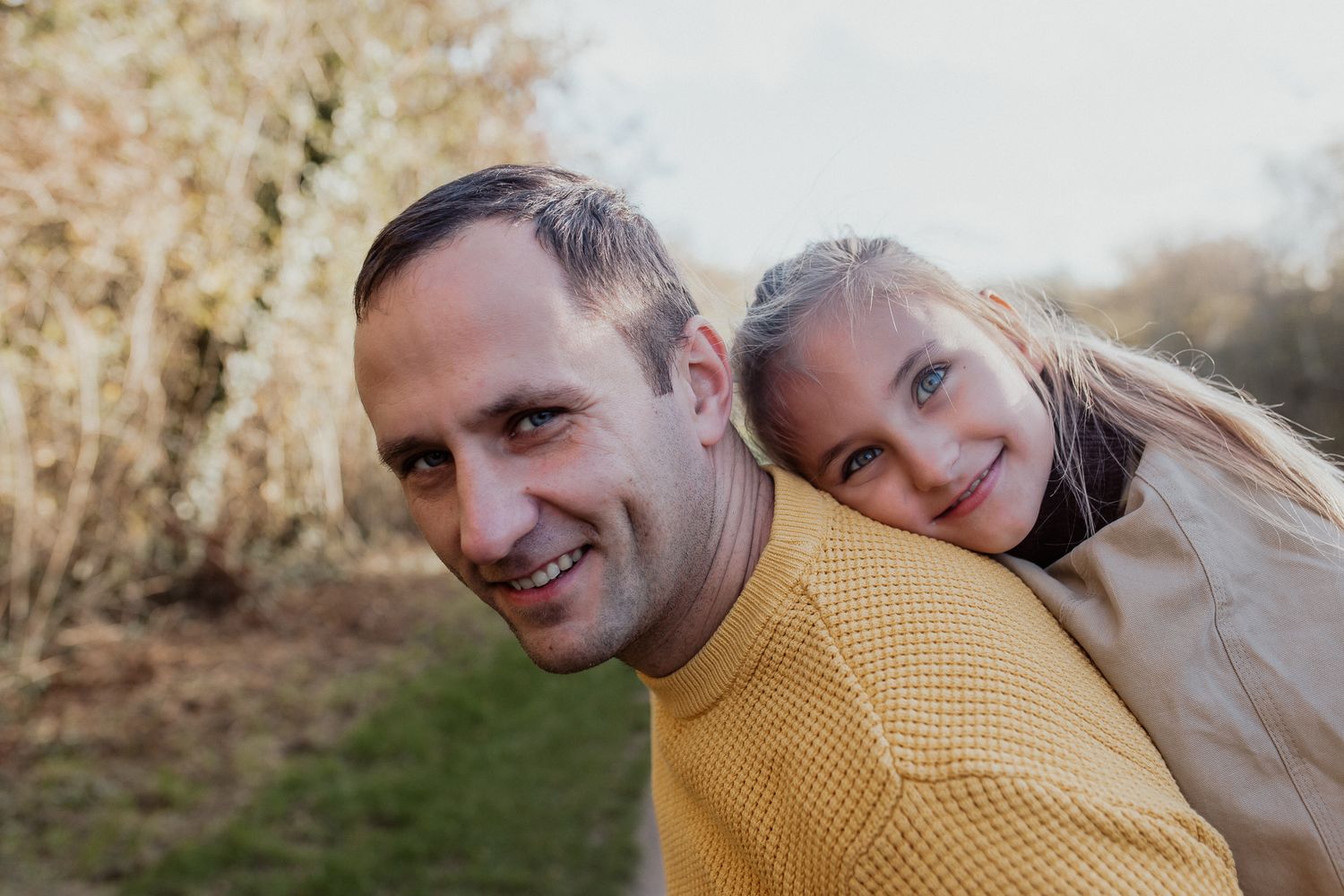 Natural family portrait of parents and children laughing together during an outdoor photography session in Kent.