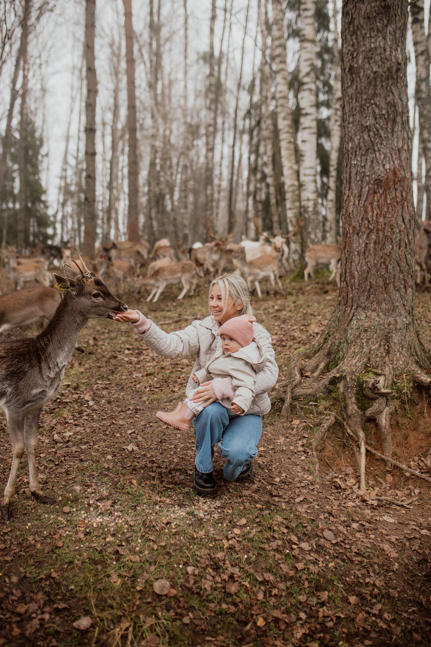 Family portrait of mother and daughter feeding deer during session in latvia