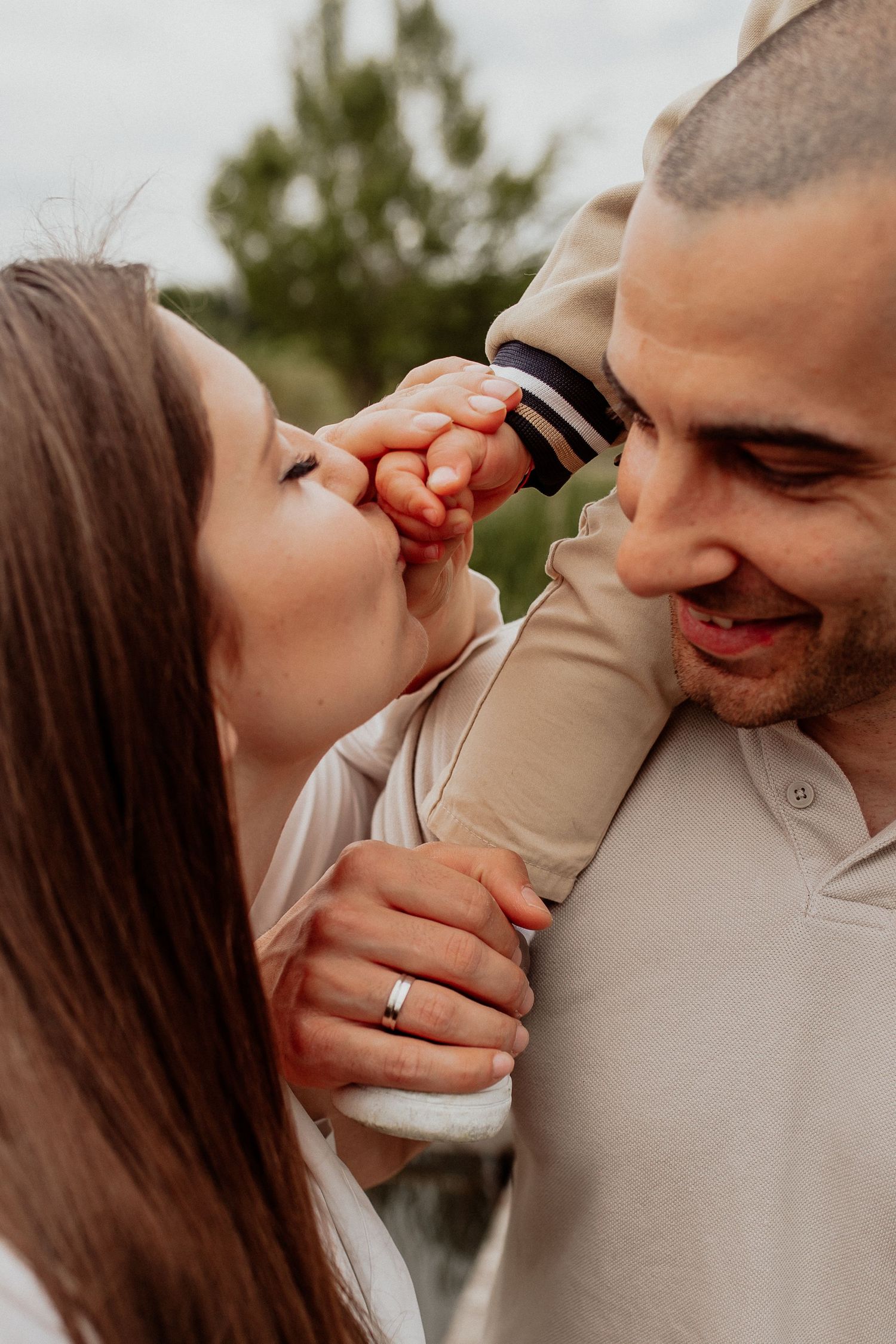 Emotional portrait showing a gentle hand touch between family members during a relaxed photography session.