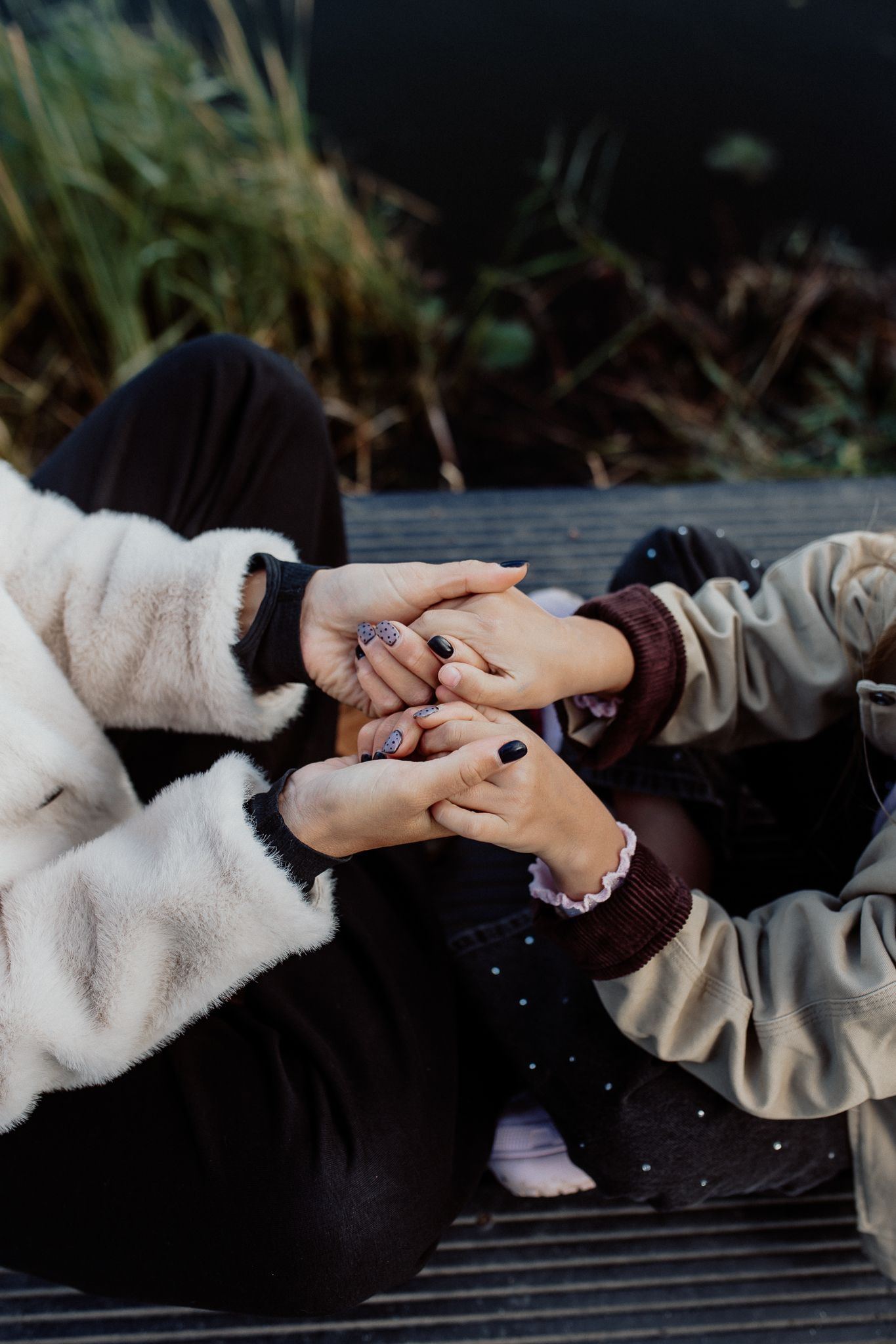 Emotional portrait showing a gentle hand touch between family members during a relaxed photography session.