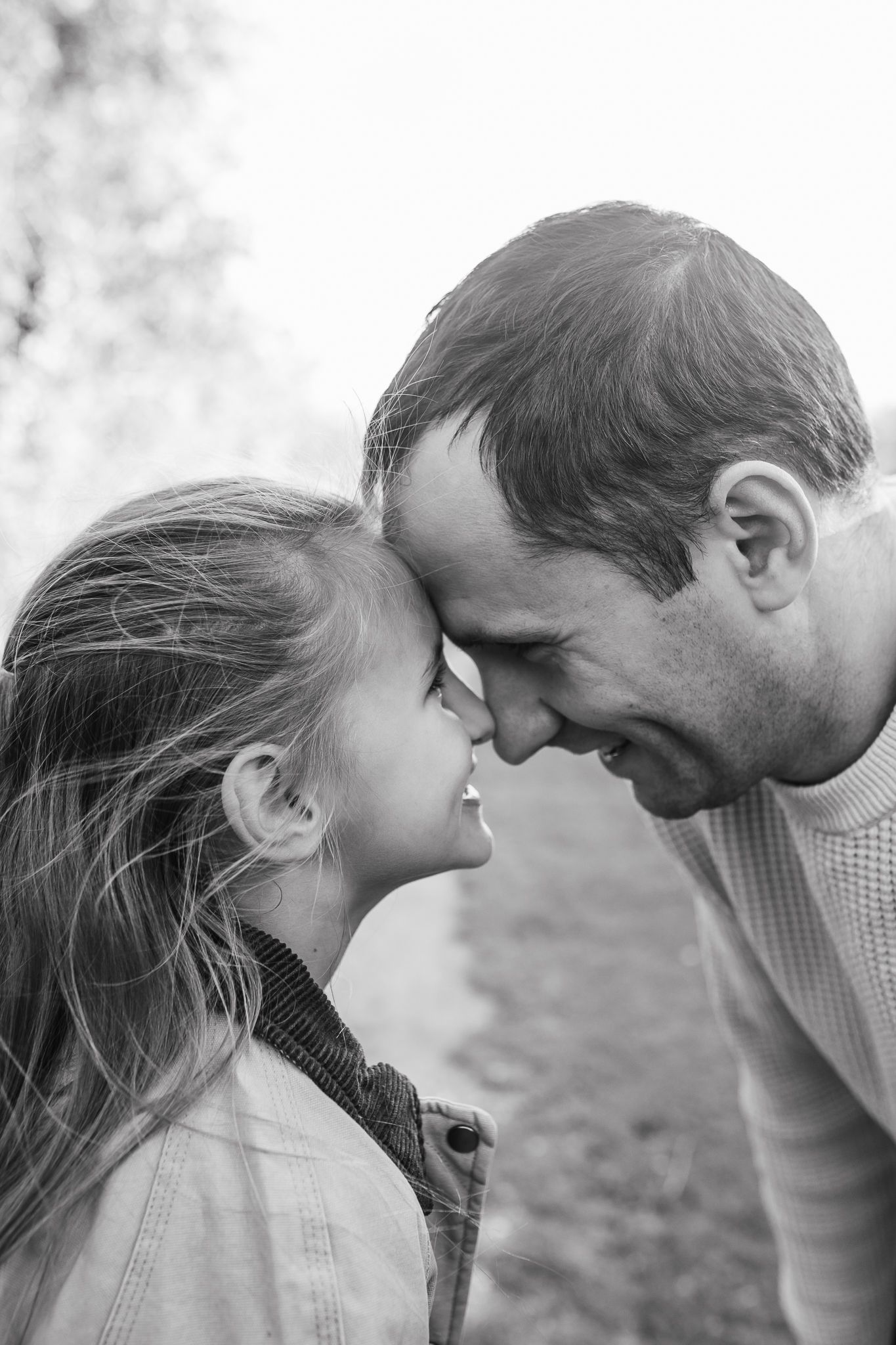 Natural family portrait of parents and children laughing together during an outdoor photography session in Kent.