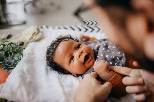 A series of intimate black and white photographs showing tender moments between parent and newborn baby.