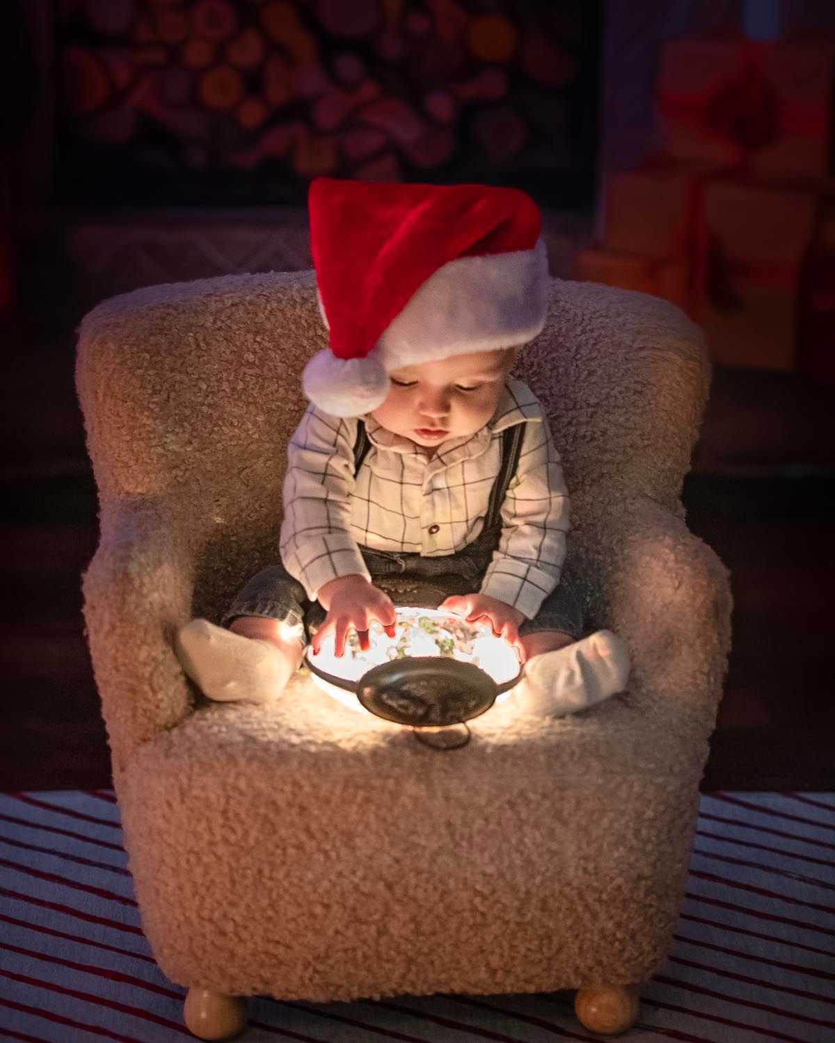 little 6 month old looking at snowglobe of santa