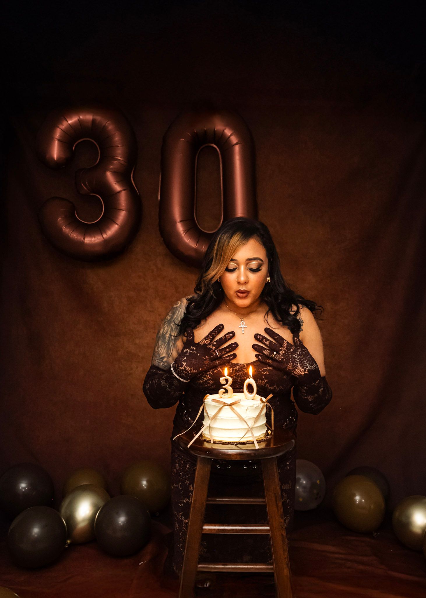 Birthday Photoshoot featuring Dramatic birthday portrait with black balloons and candles in moody lighting.