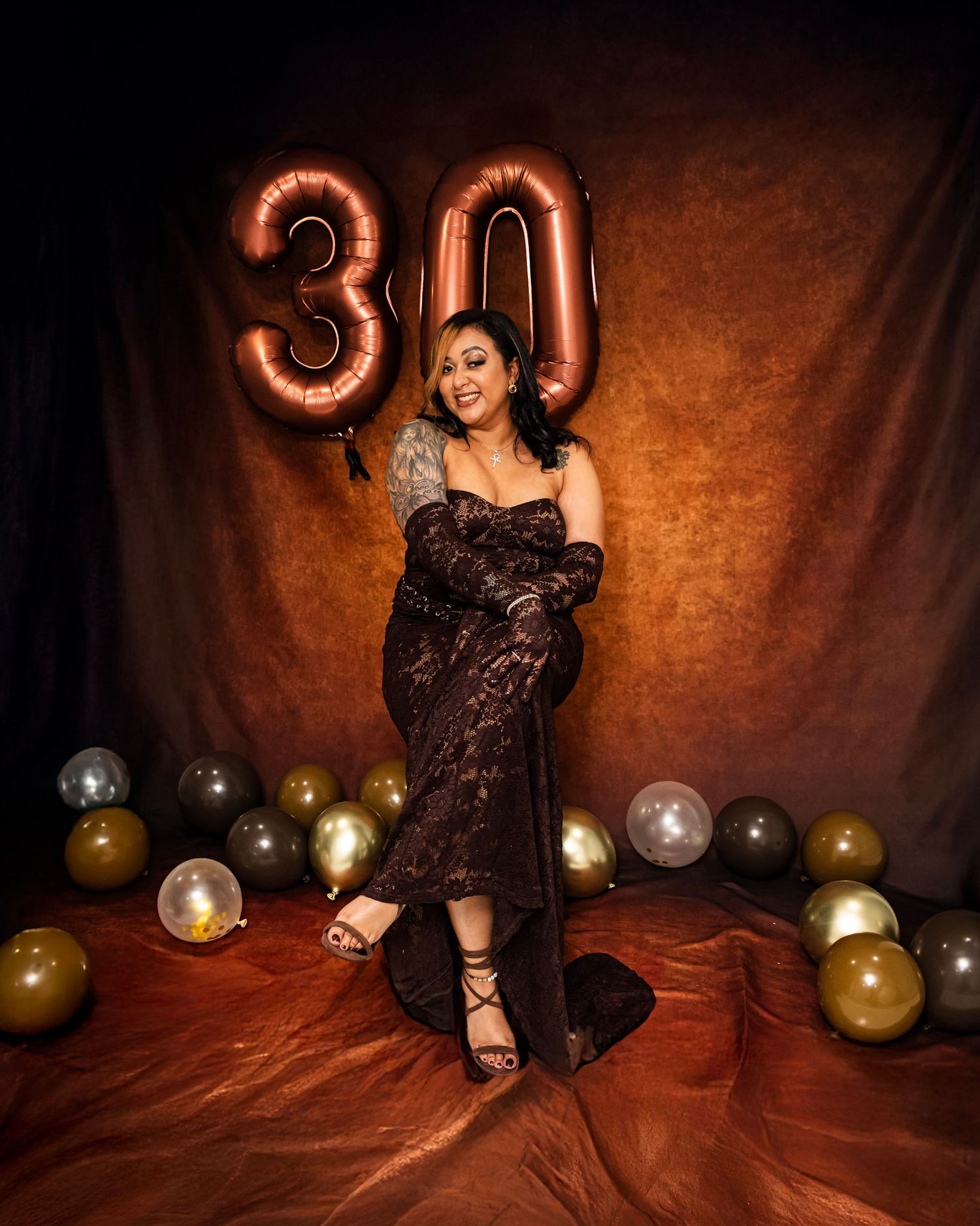 Birthday Photoshoot featuring Artistic studio portrait with gold balloons and dark background creating dramatic lighting effects.