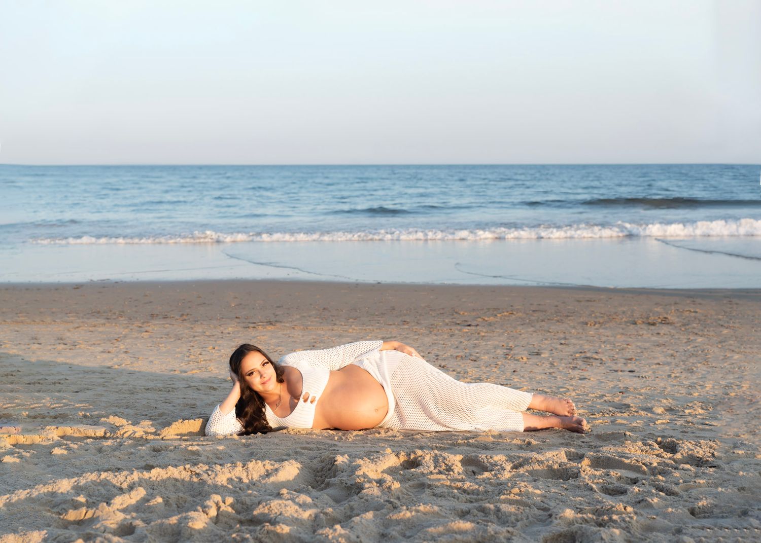 Maternity Photoshoot featuring Sandy beach landscape with waves and ocean horizon during daytime.