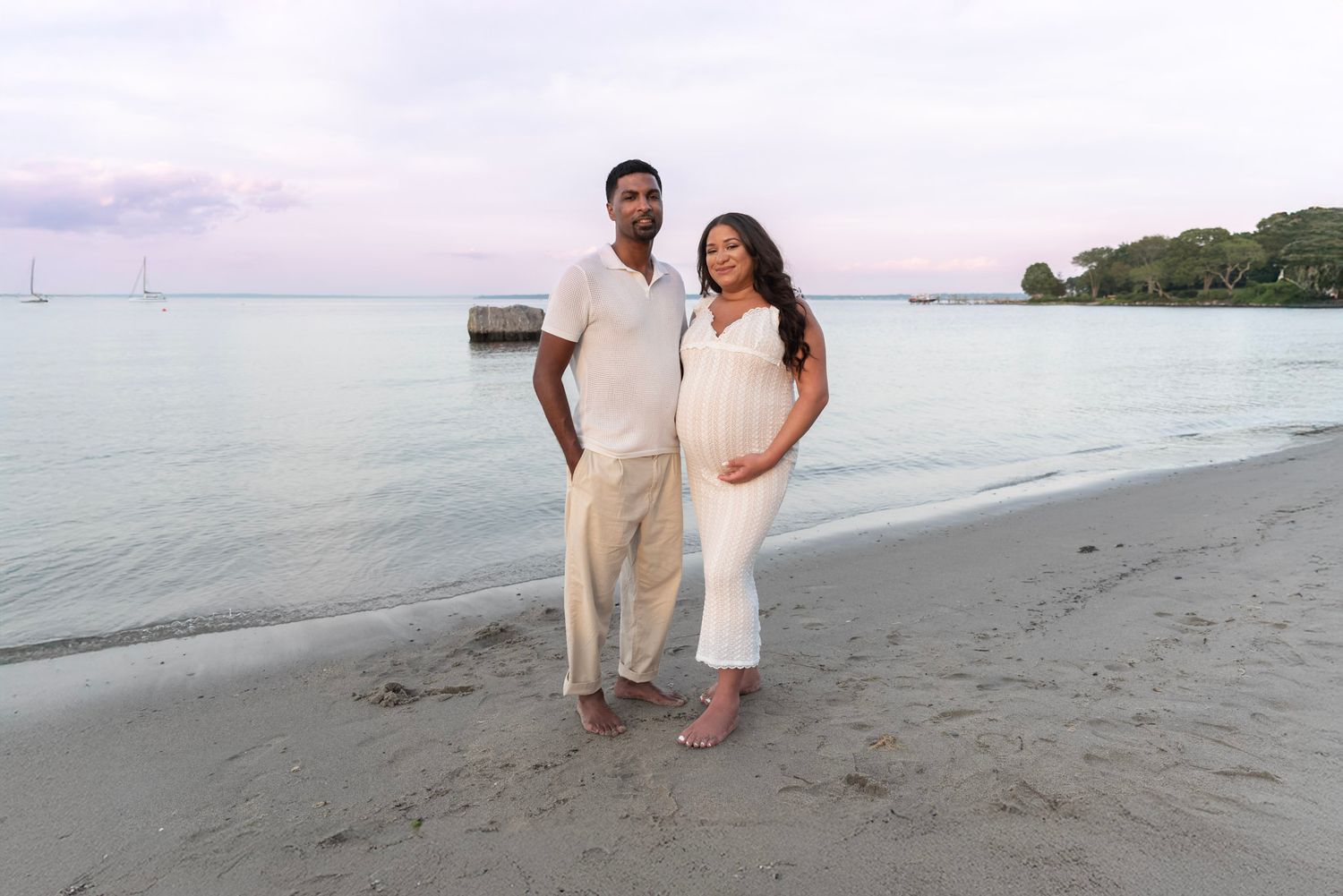 Romantic couple photoshoot on a sandy beach during golden hour.