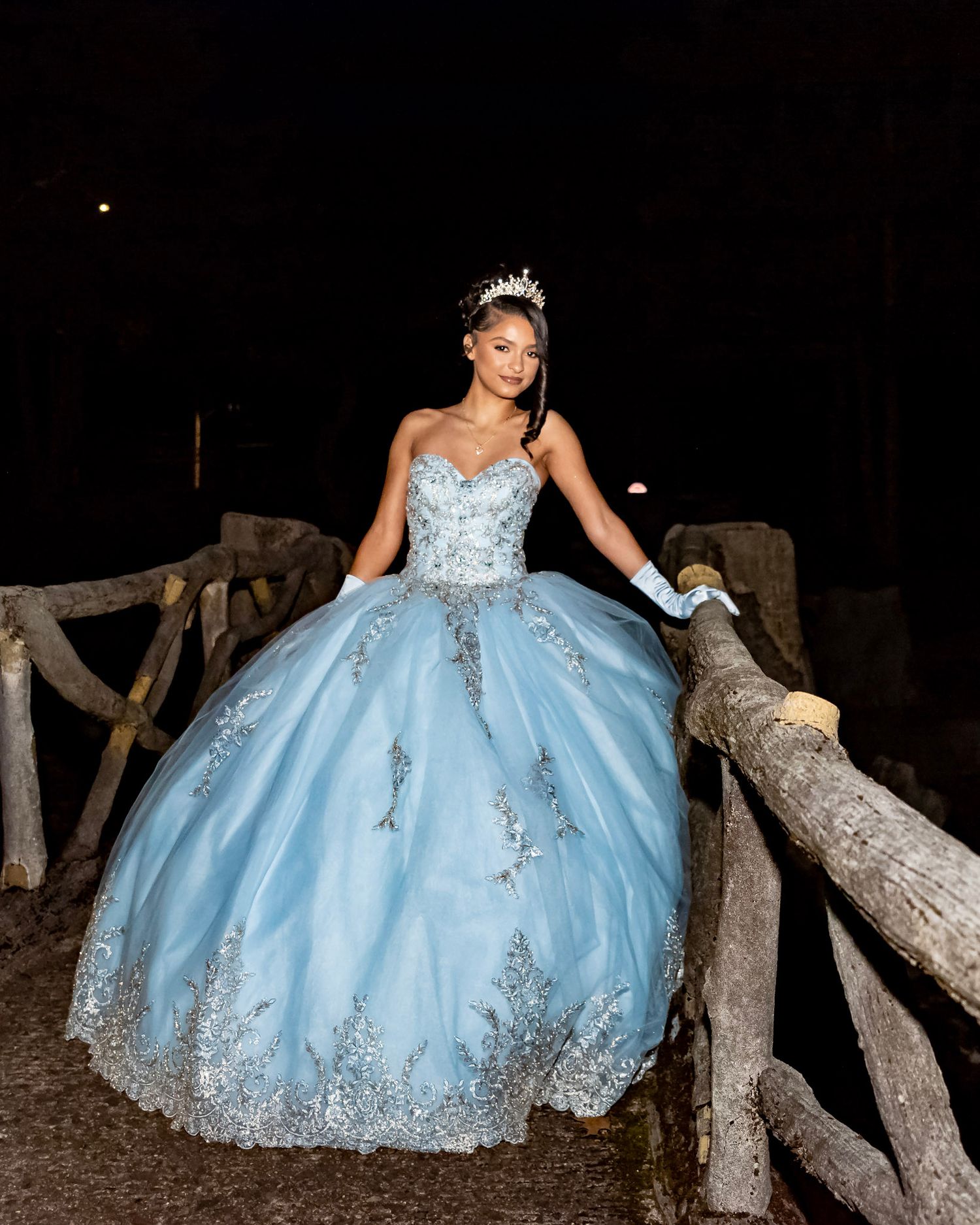 Nighttime outdoor photoshoot featuring a light blue ballgown with silver embellishments.