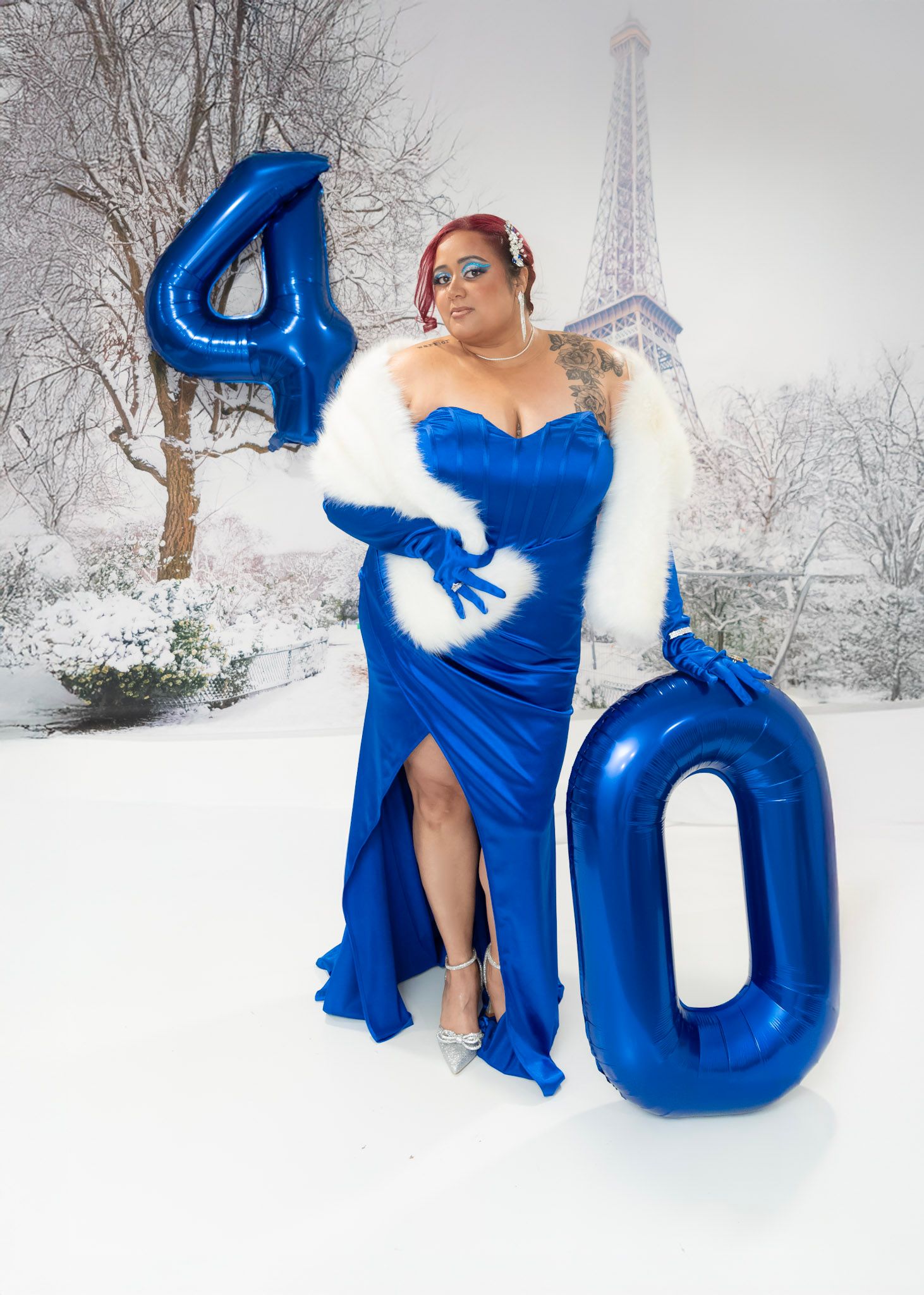 Winter portrait session with large blue number balloons against snowy background.