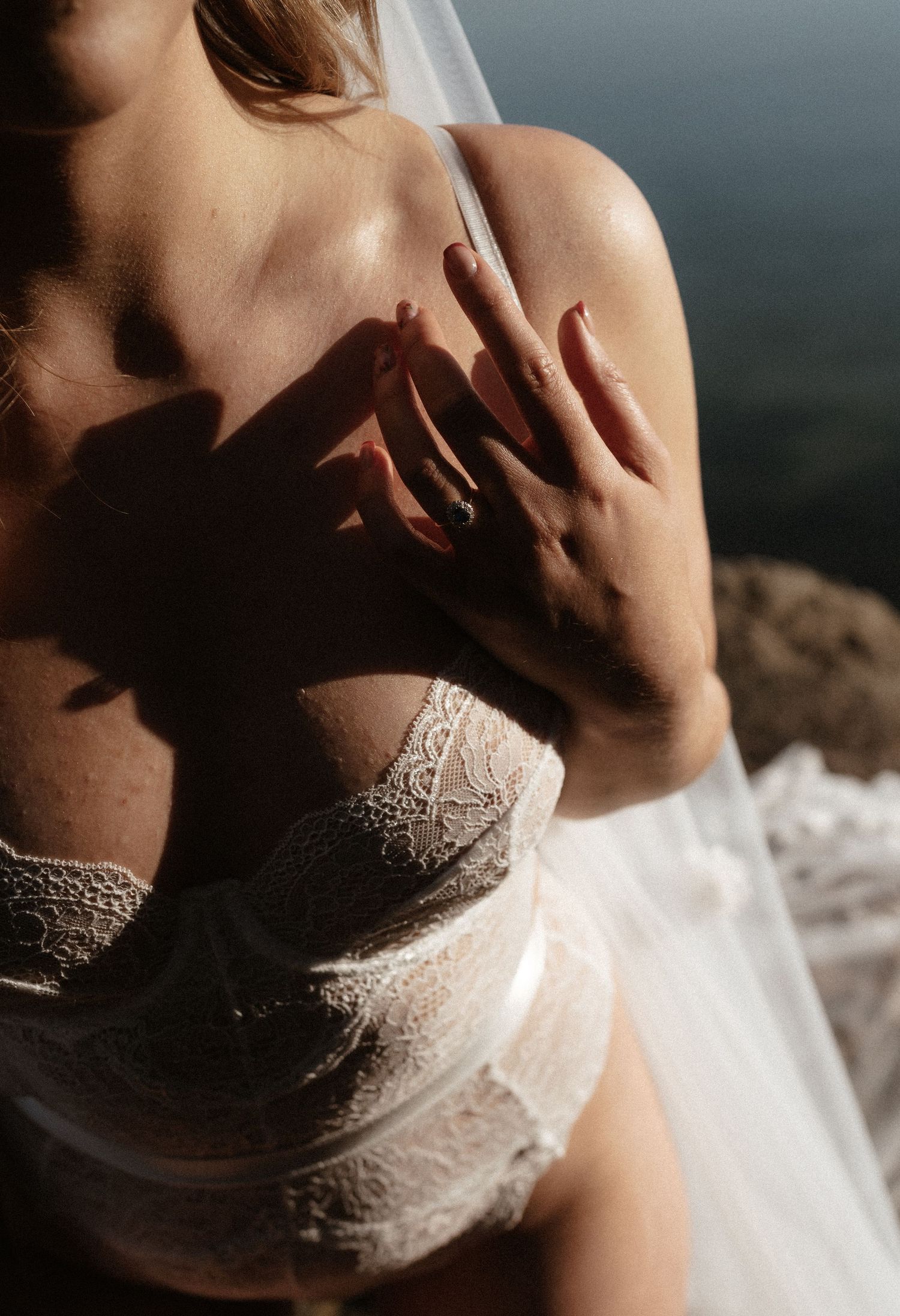 Artistic close-up of lace bridal lingerie in natural sunlight.