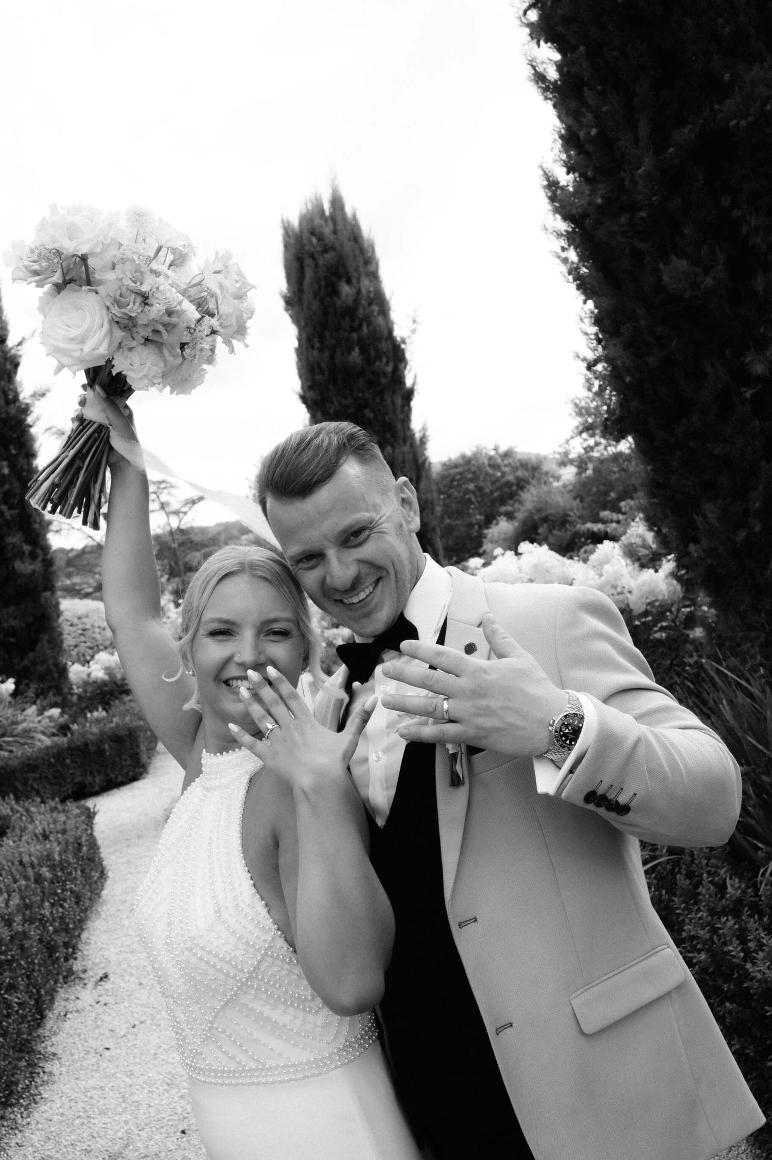 Wedding couple makes silly faces and poses in black and white portrait series.