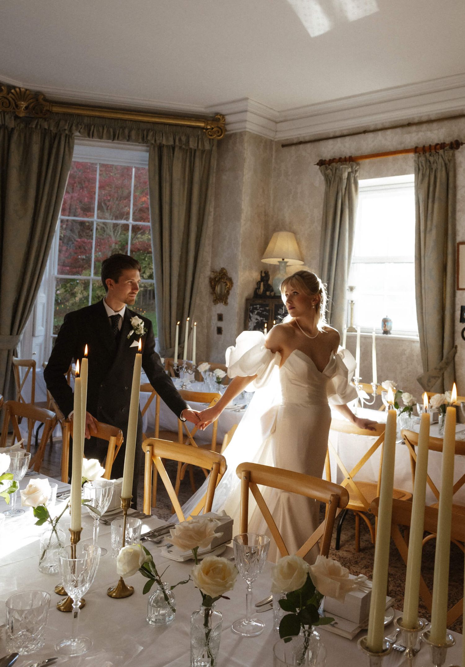 Elegant wedding reception table setting in a traditional dining room with candlelight.