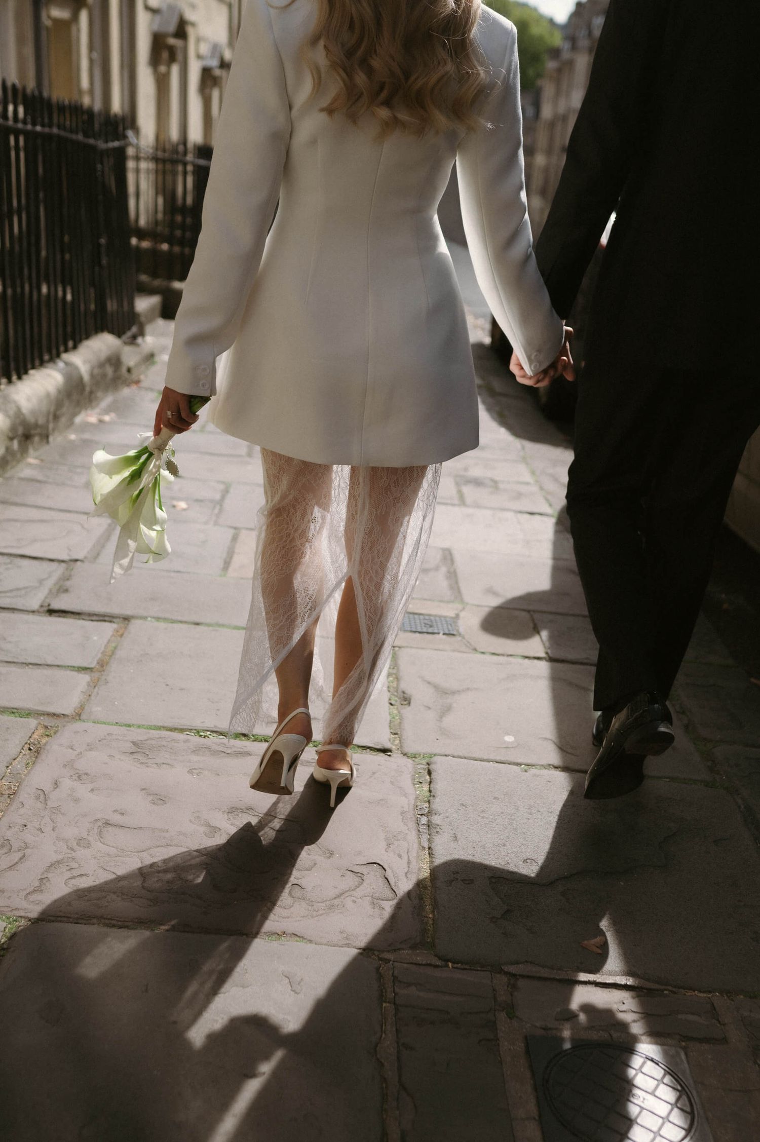 Close-up of feet walking along stone pavement at a formal event.