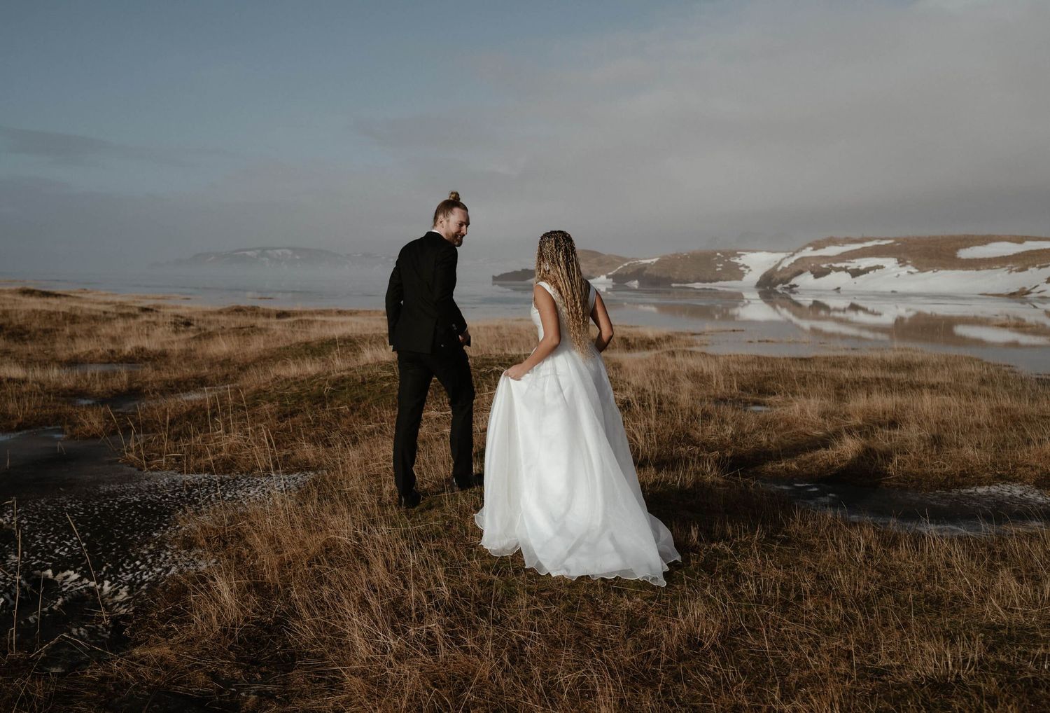 Dramatic coastal wedding photos taken against rugged ocean landscape.