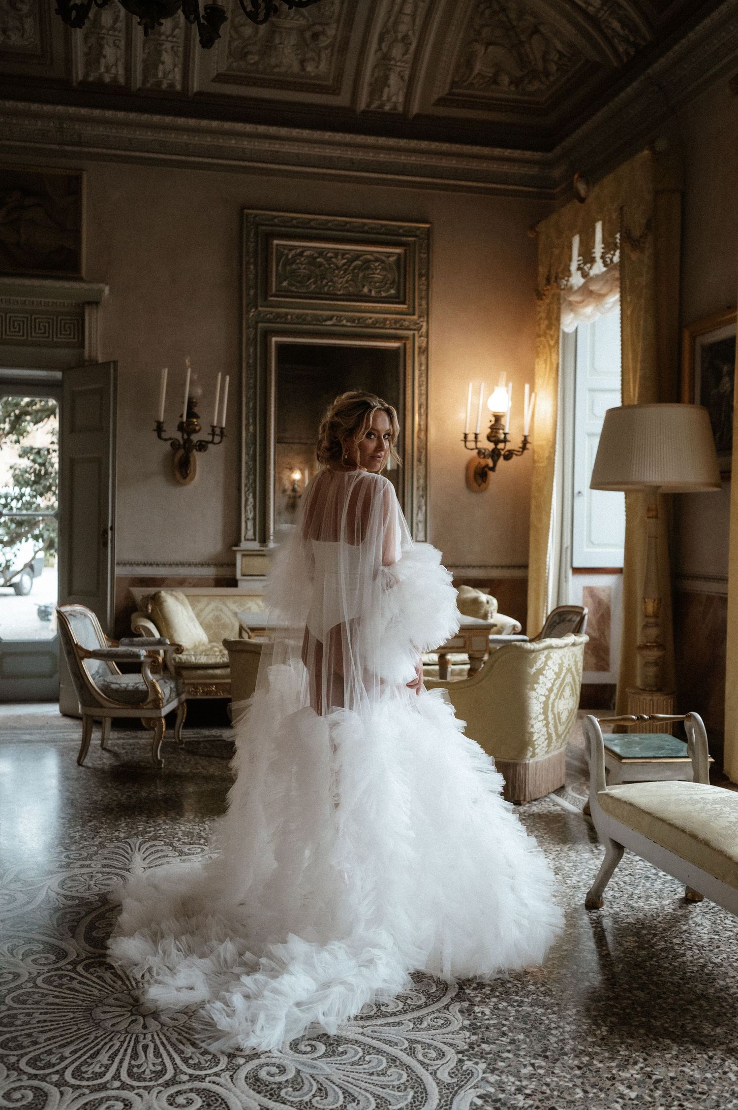 Ethereal bridal portrait in an elegant room with ornate details and flowing white gown.