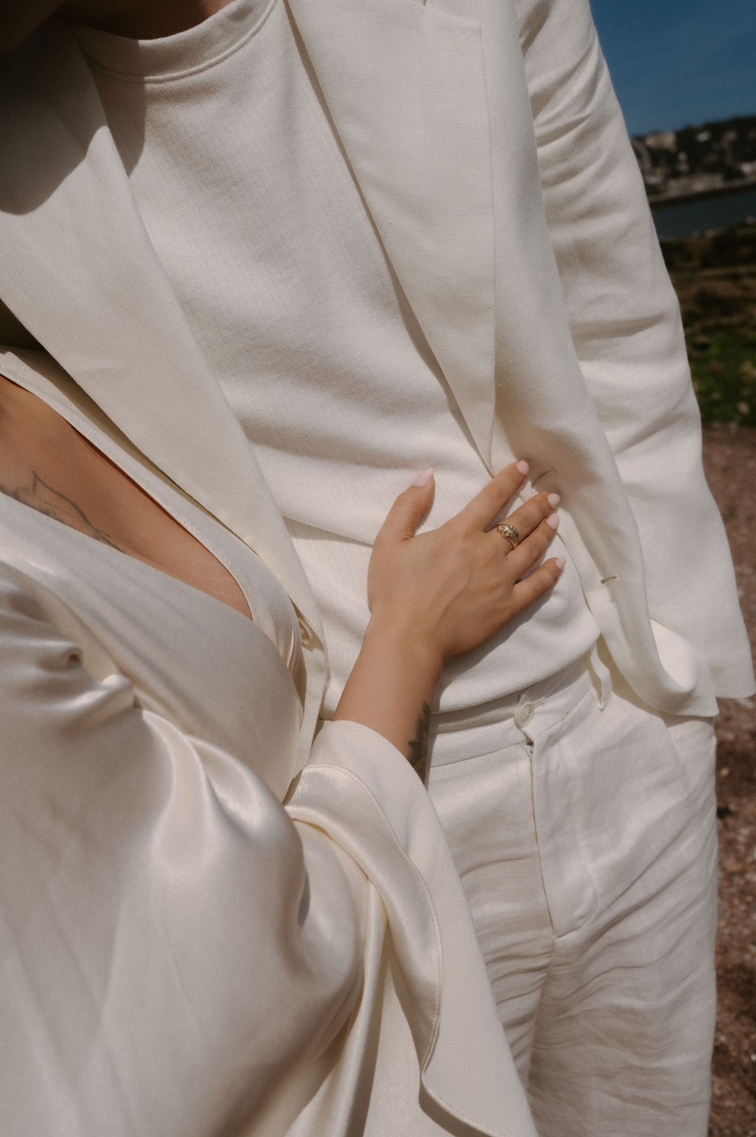 Close-up detail shots of white wedding attire showing fabric texture and styling details.