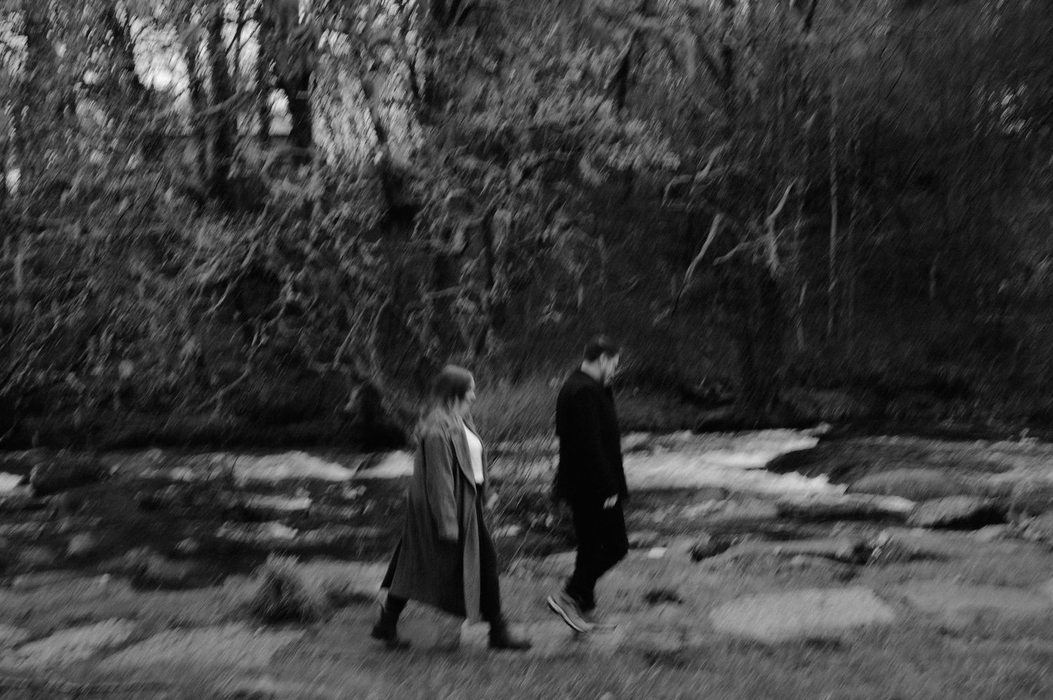 A couple poses together in a romantic winter forest setting.