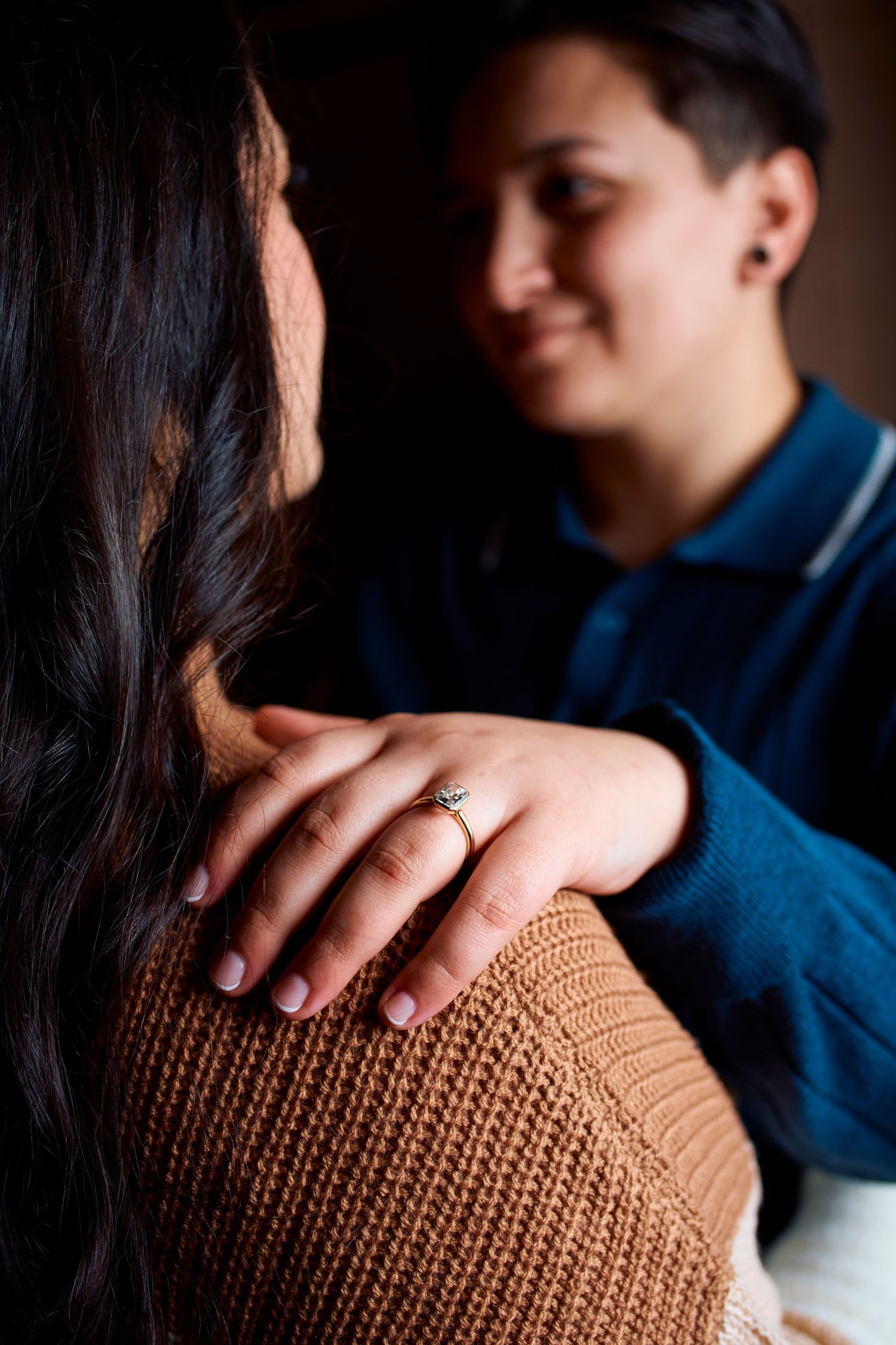 Close-up detail shots focusing on hand placement on brown knit sweater.