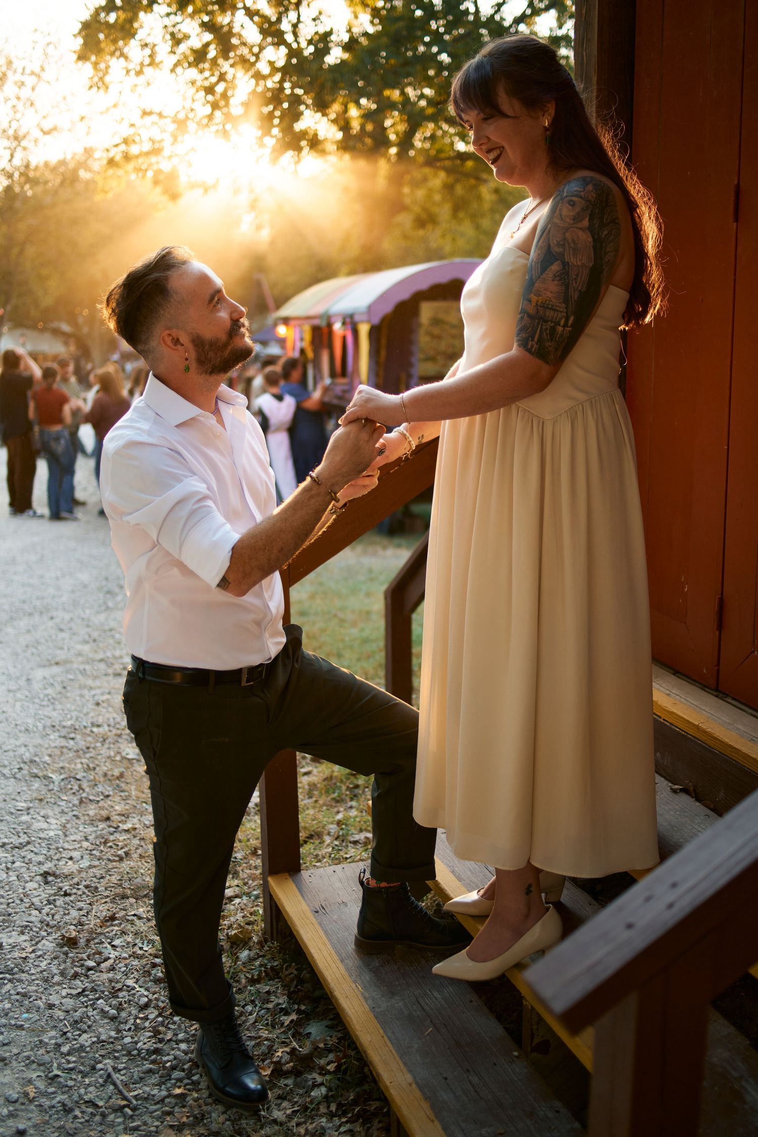 Sunset proposal scene at rustic wooden venue with golden hour lighting.