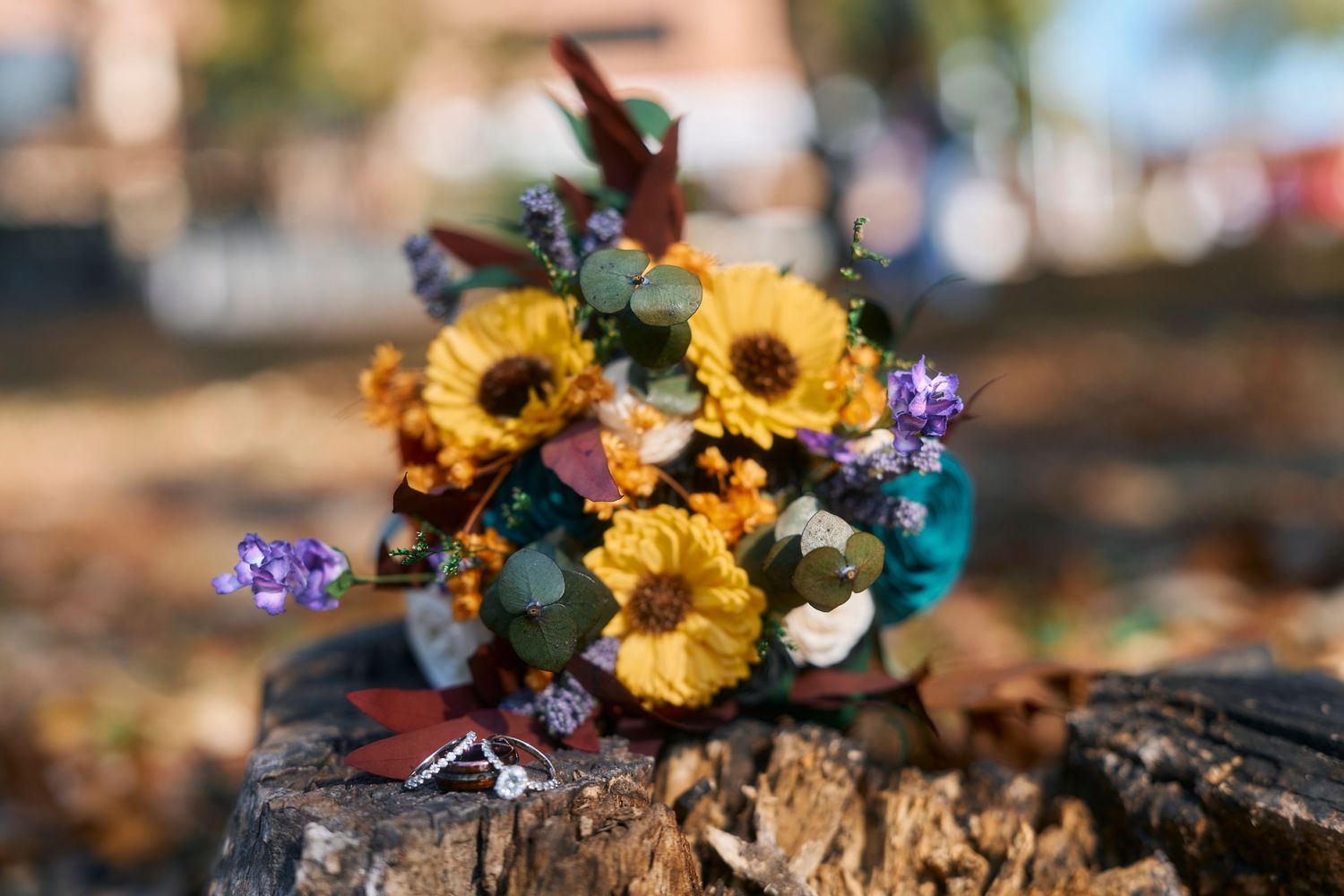 Colorful sunflowers and wildflowers arranged in rustic fall decor.