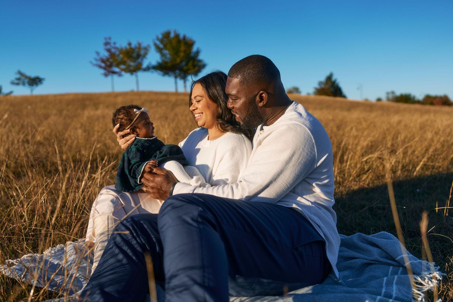 Couple enjoying a romantic moment in sunny field with tall grass.