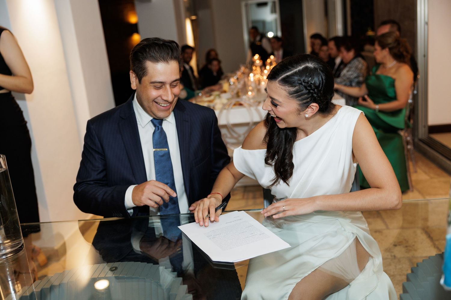 Celebratory moment at a wedding reception with guests seated at tables indoors.