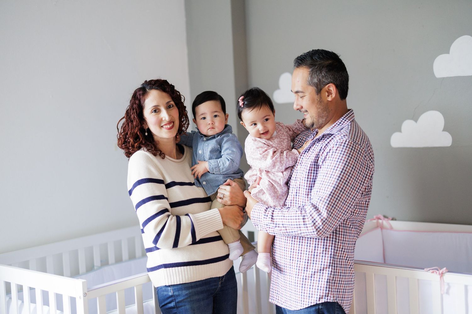 Family portrait session in a bright, minimalist room with white walls.