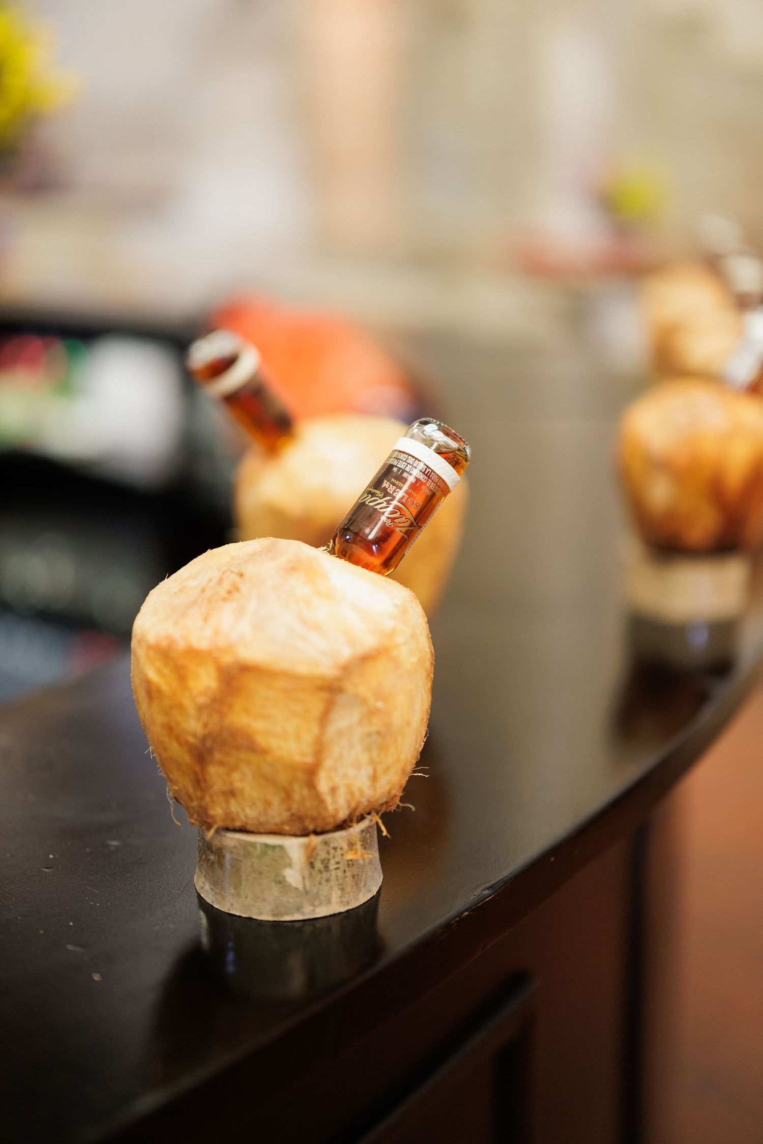 Small pastries with bottles displayed on dark counter at catered event.