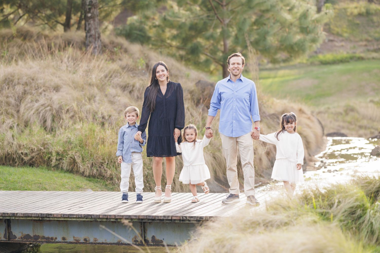 Group walking along coastal path during golden hour.