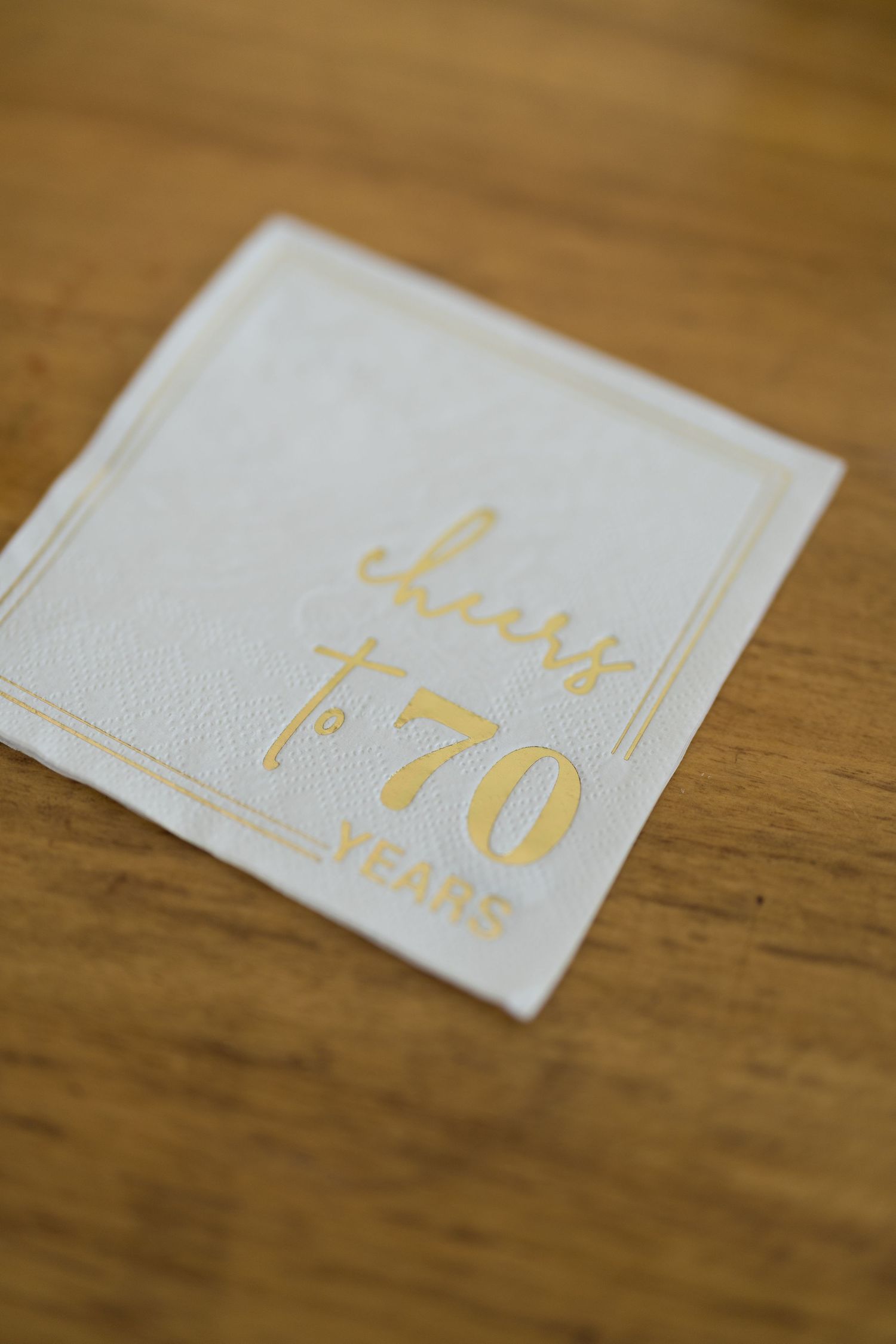 Close-up of elegant white wedding stationery with gold text details.